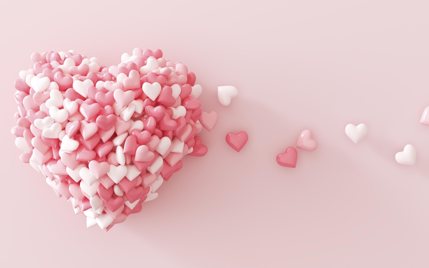 Сердце из маленьких сердечек на розовом фоне