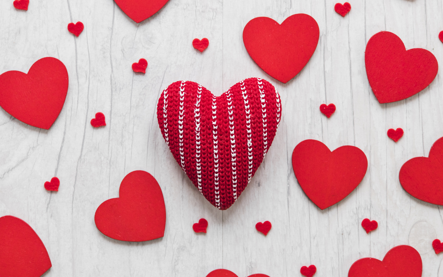Много красных сердец на белом деревянном столе