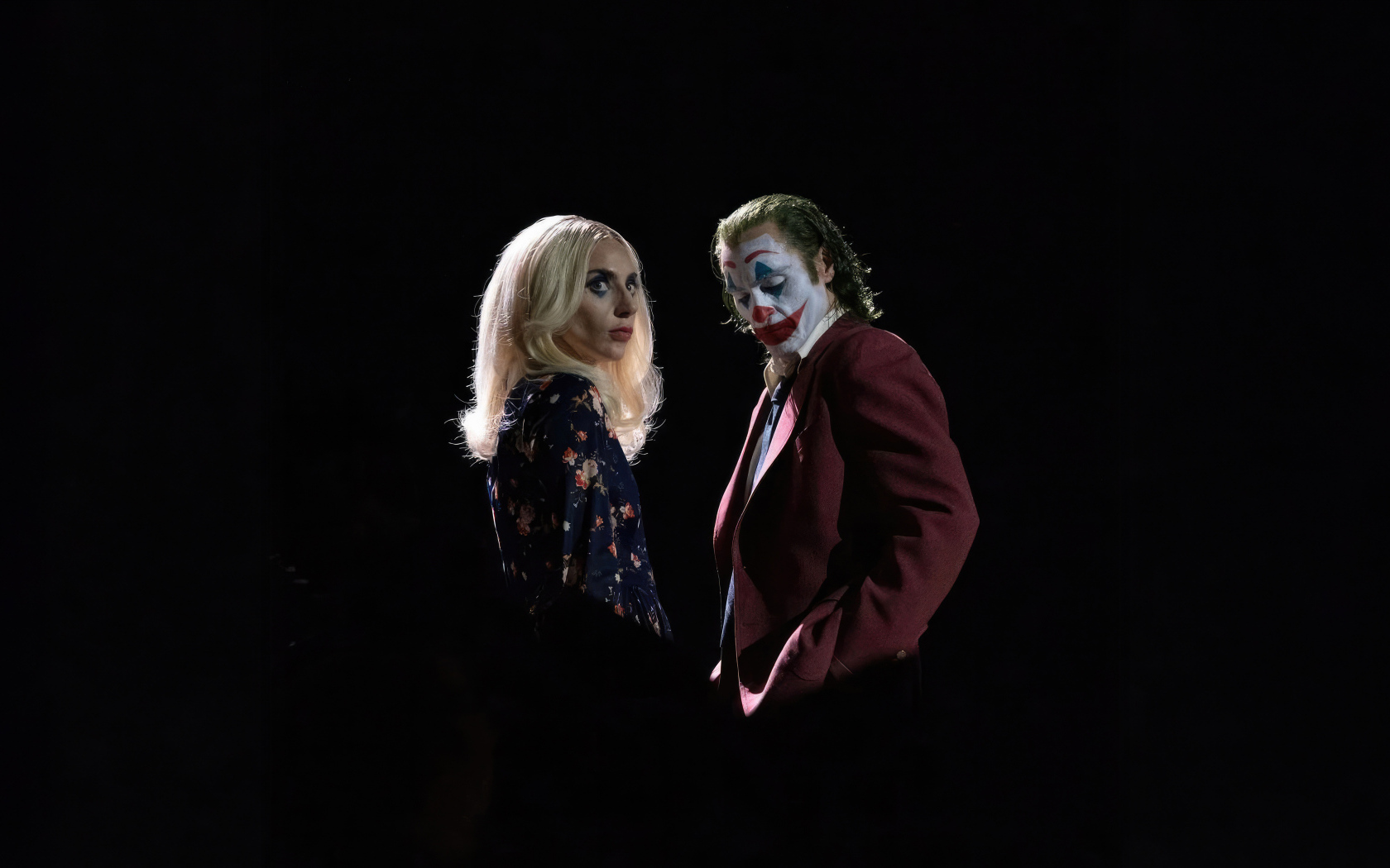 Главные герои фильма Джокер: Безумие на двоих на черном фоне