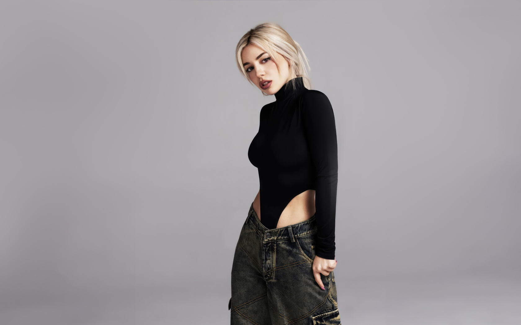 Милая блондинка певица  Эйва Макс на сером фоне