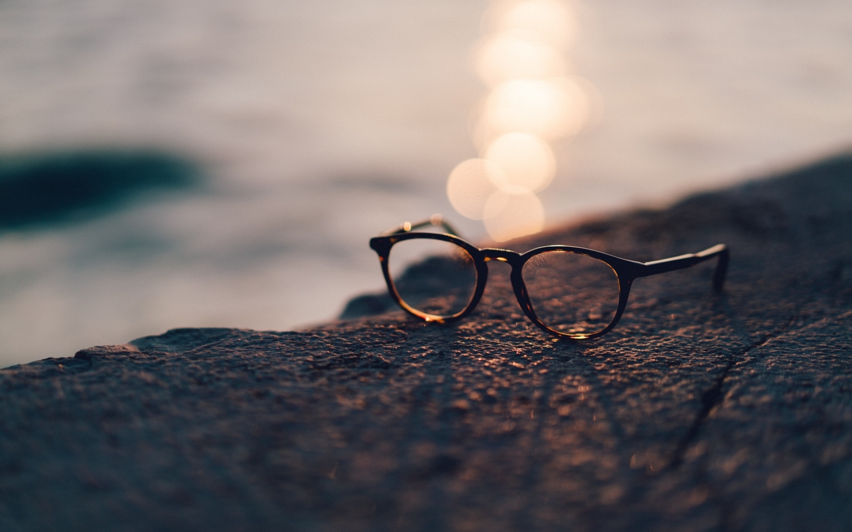 Очки лежат на камне в лучах солнца