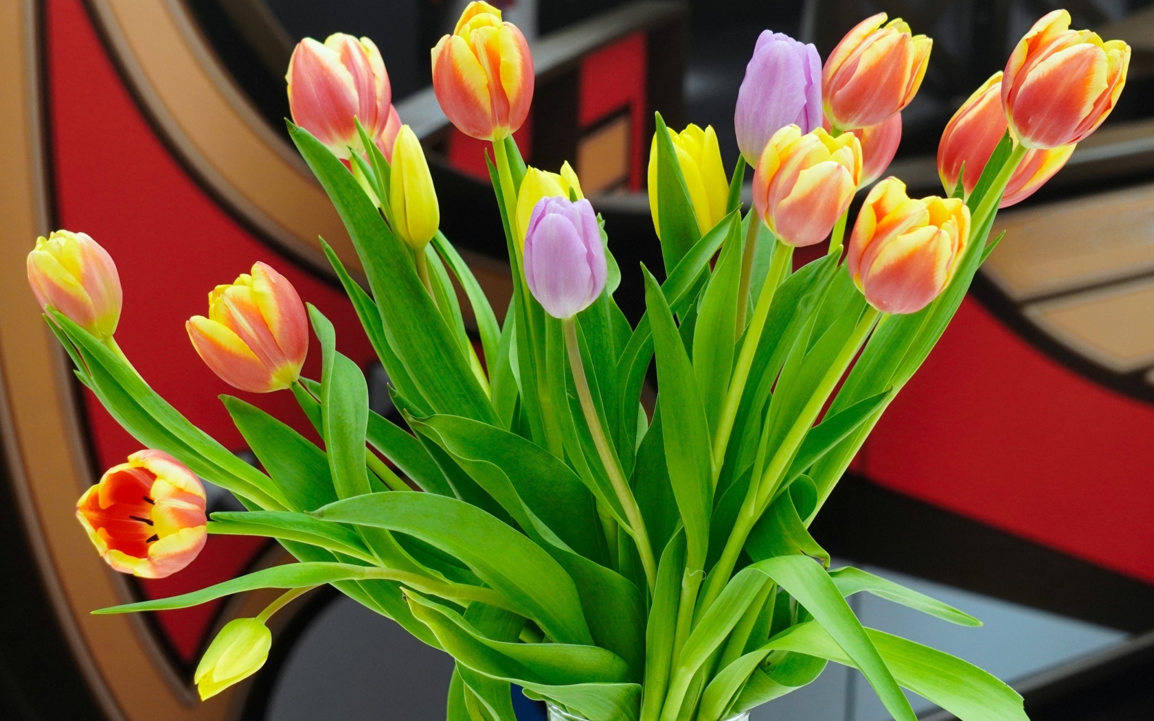Букет красивых разноцветных тюльпанов в стеклянной вазе