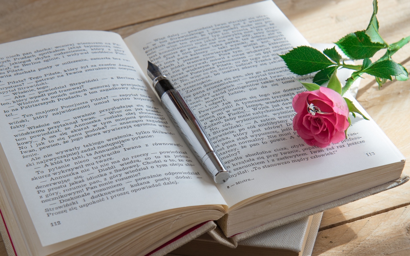 Розовая роза с кольцом на книге 