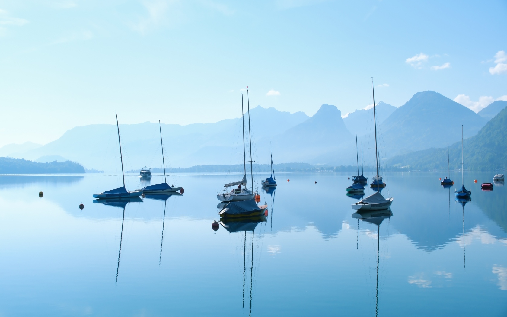 Лодки на озере у гор на рассвете в тумане