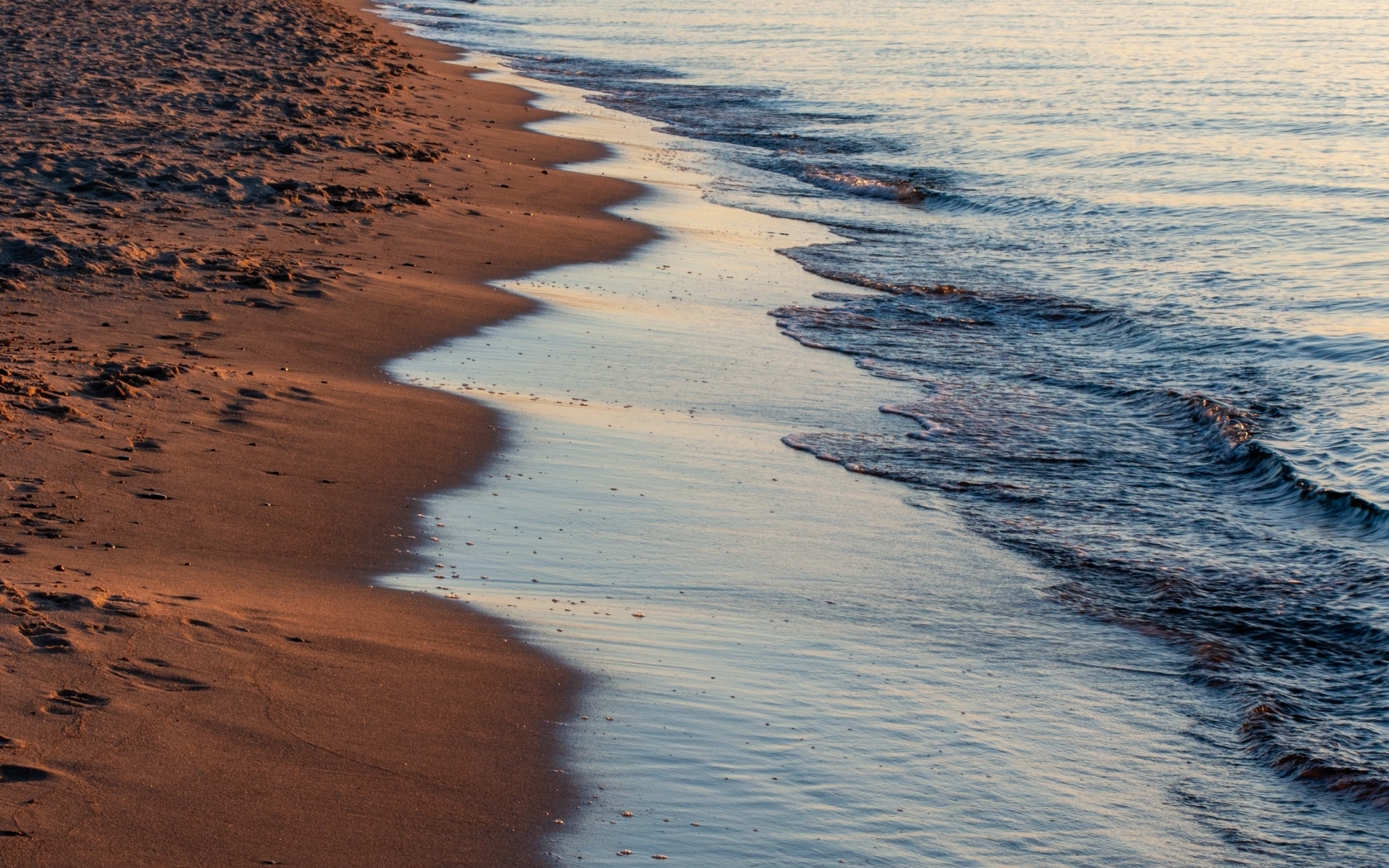Спокойное море на морском песке на рассвете