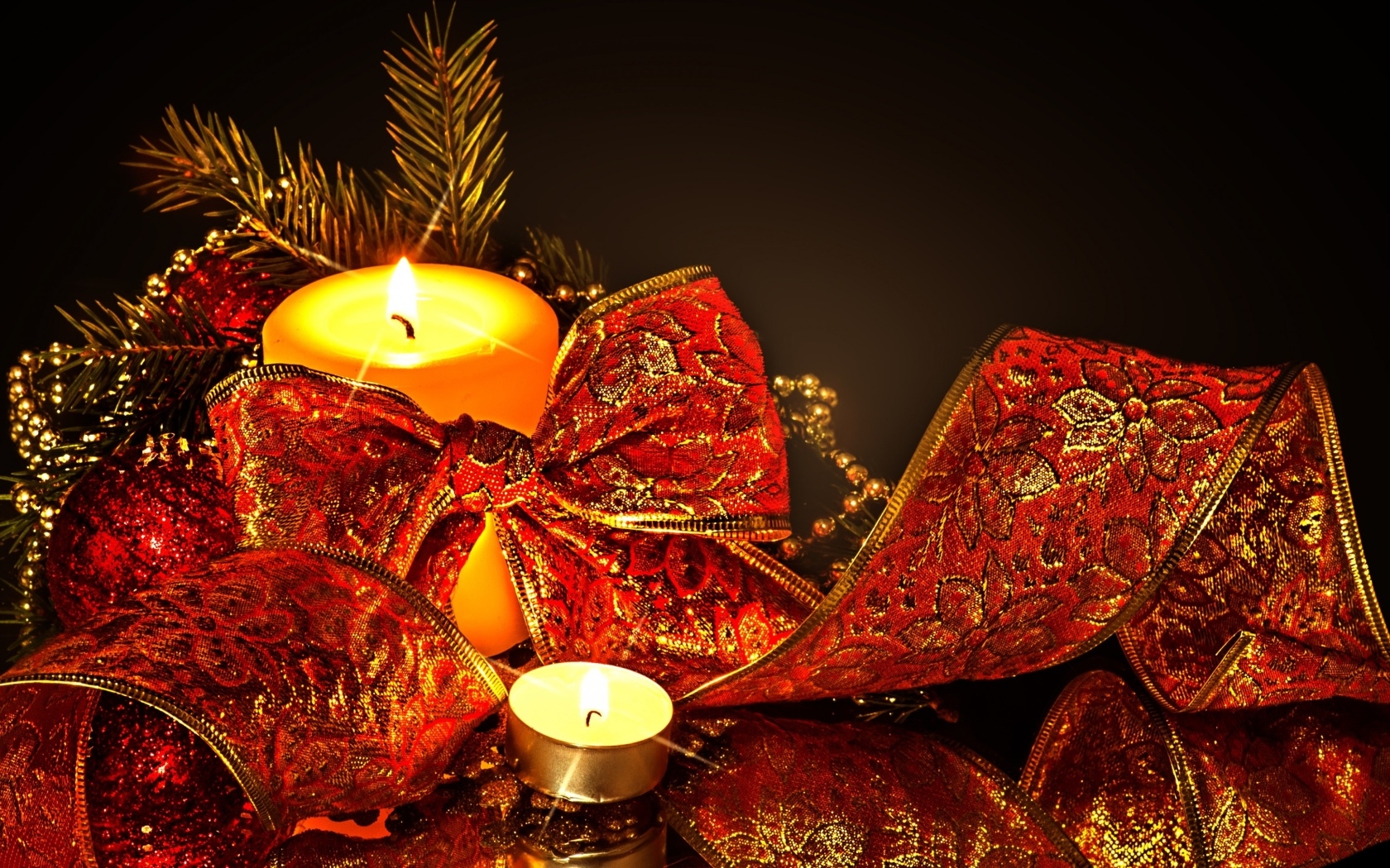 Зажженная свеча с красным бантом на черном фоне на Новый год