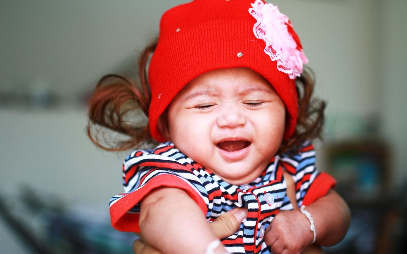 Девочка в красной шапке плачет на руках