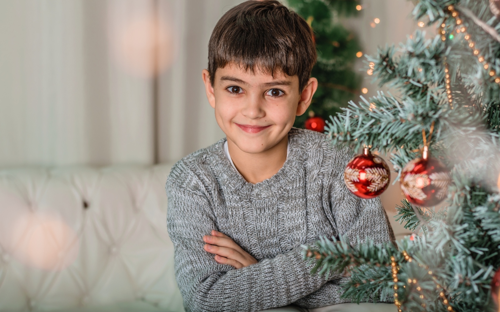 Кареглазый мальчик у новогодней ели