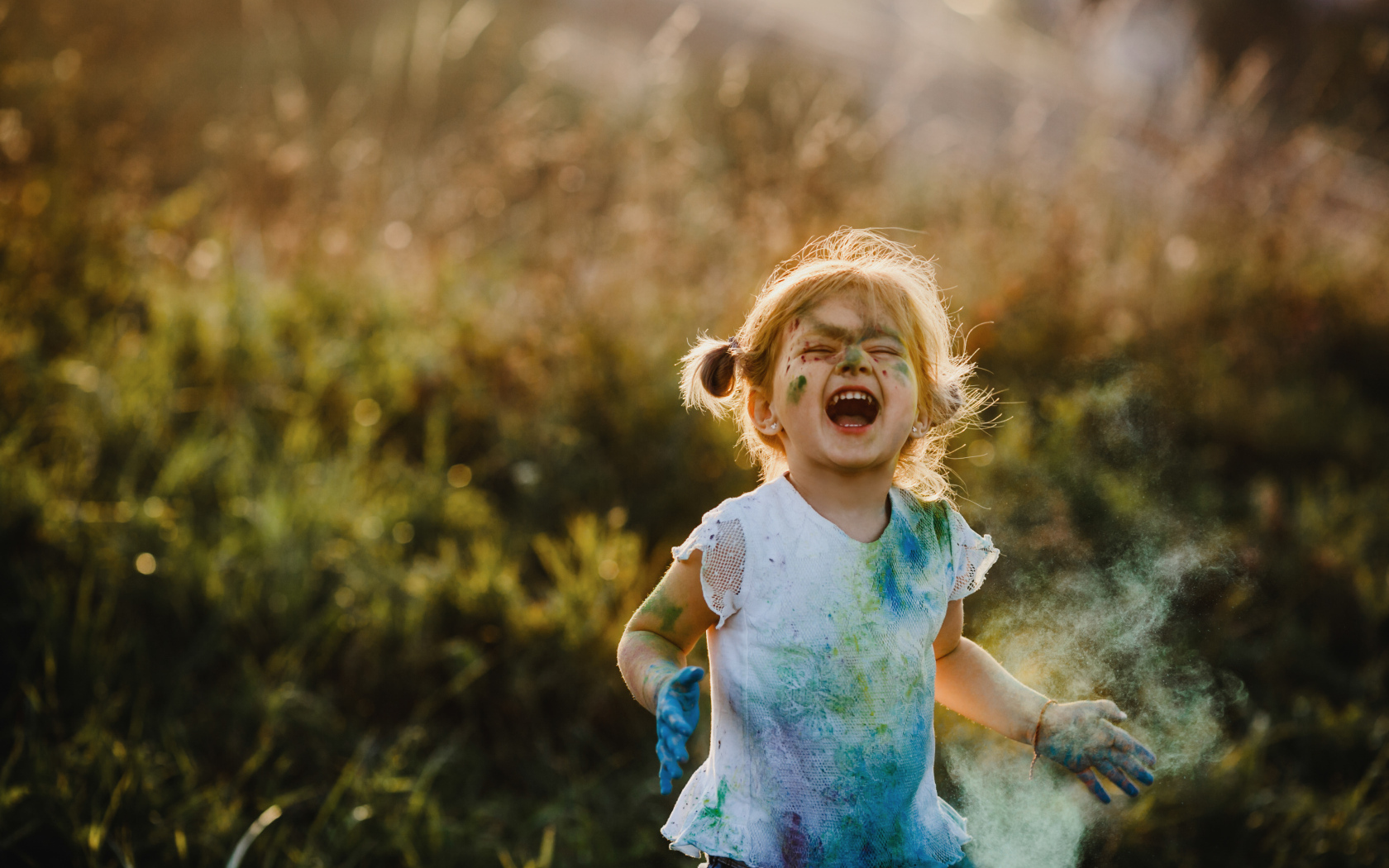 Веселая девочка в краске на улице