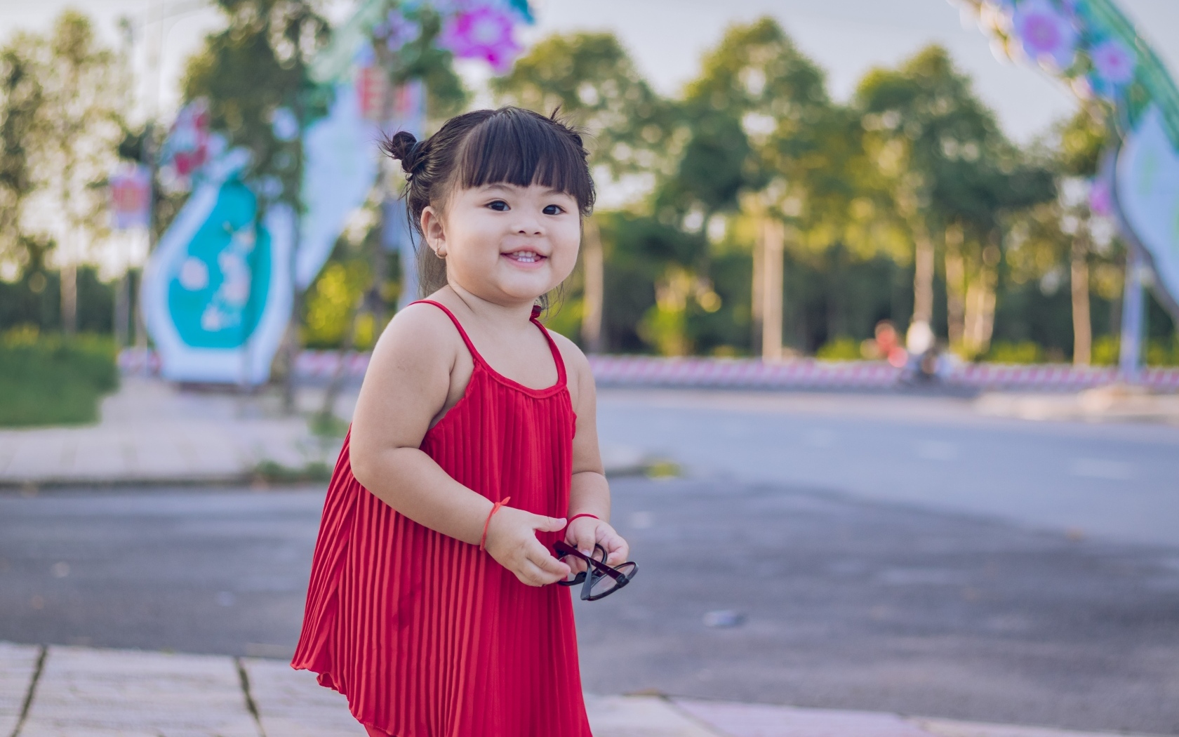 Веселая маленькая девочка азиатка в красном платье