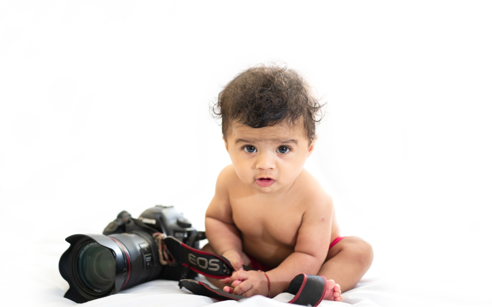Милый ребенок с фотоаппаратом на белом фоне
