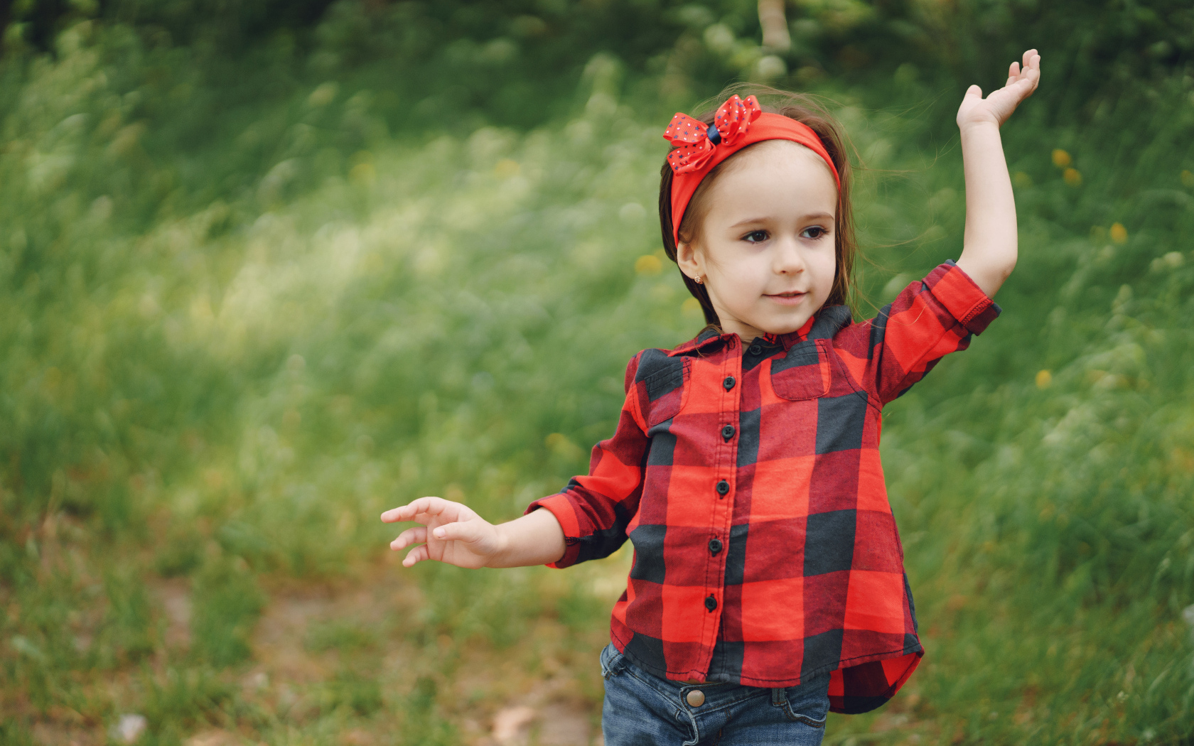 Милая девочка с красным бантом на голове 