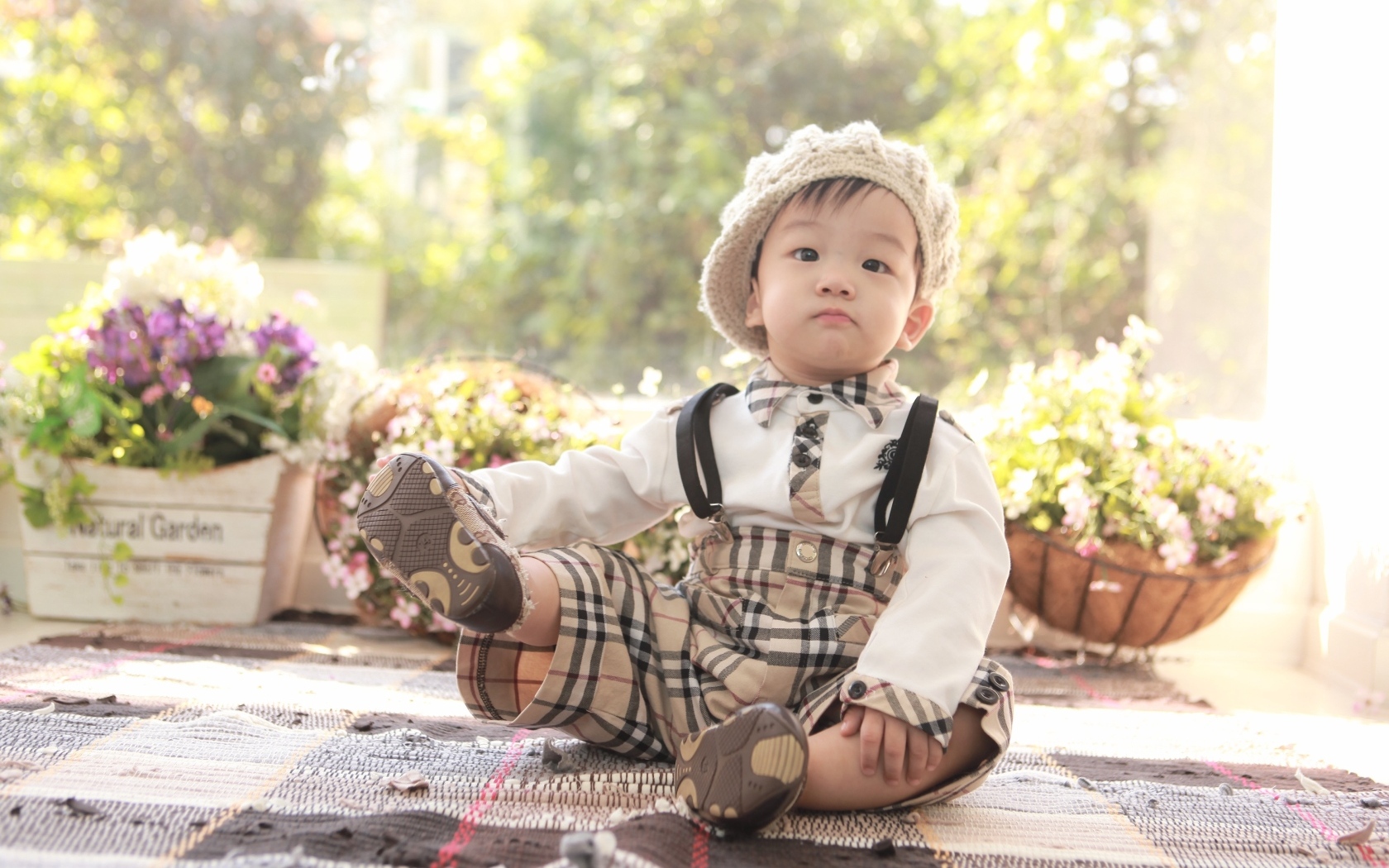 Смешной мальчик азиат у цветов