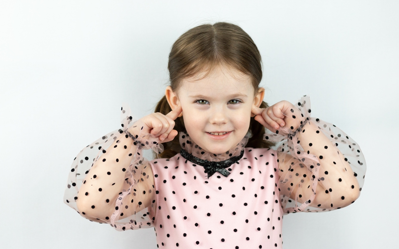 Смешная маленькая девочка закрыла уши