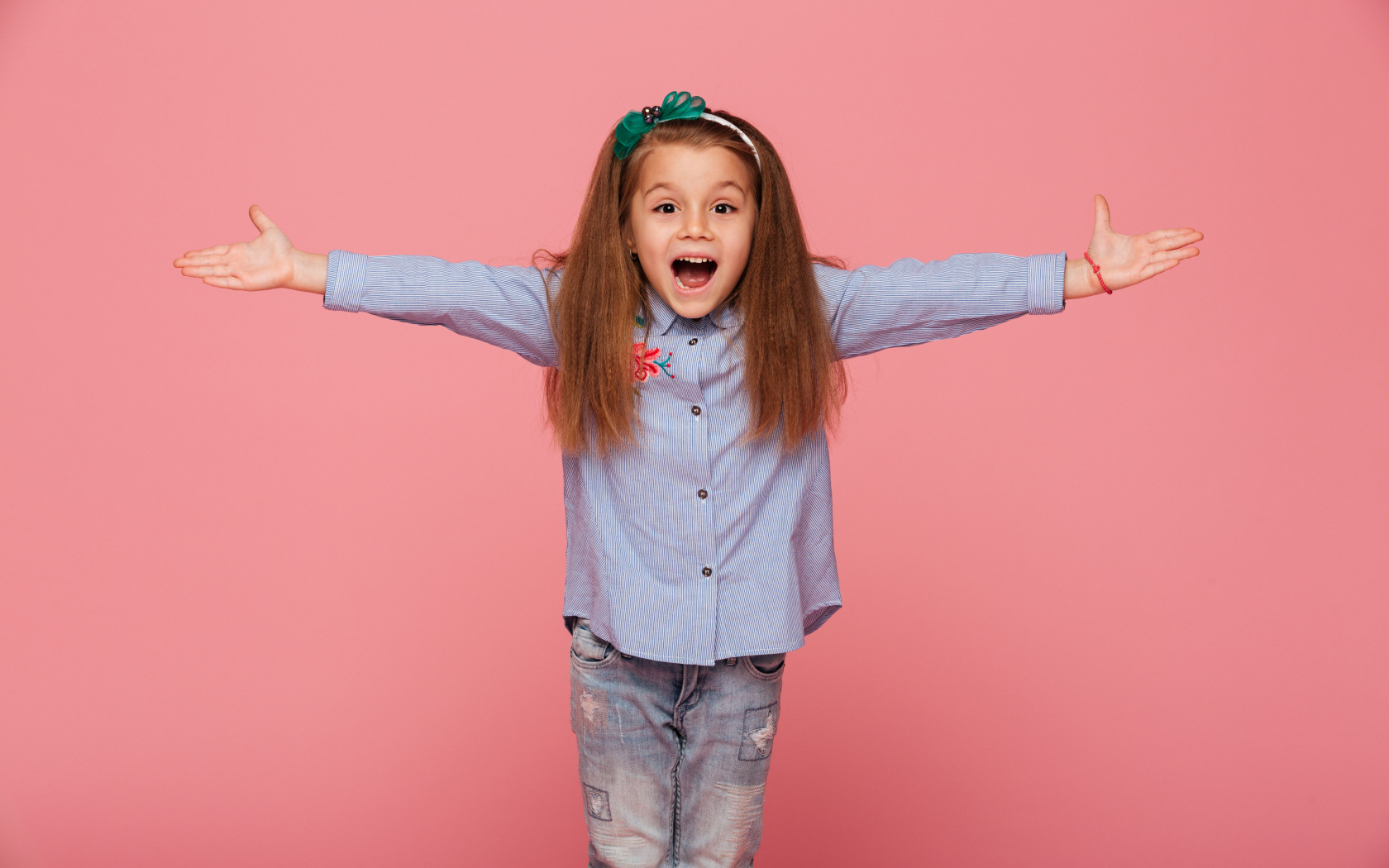 Счастливая маленькая девочка на розовом фоне