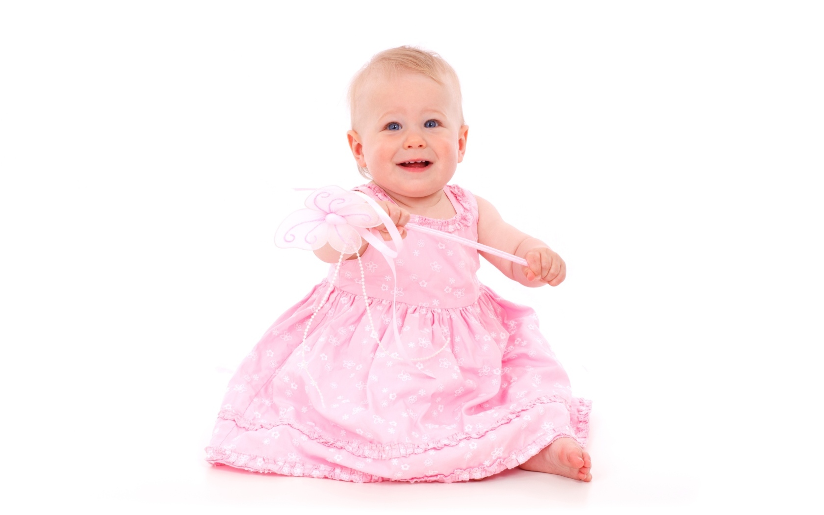 Маленькая девочка в розовом платье на белом фоне