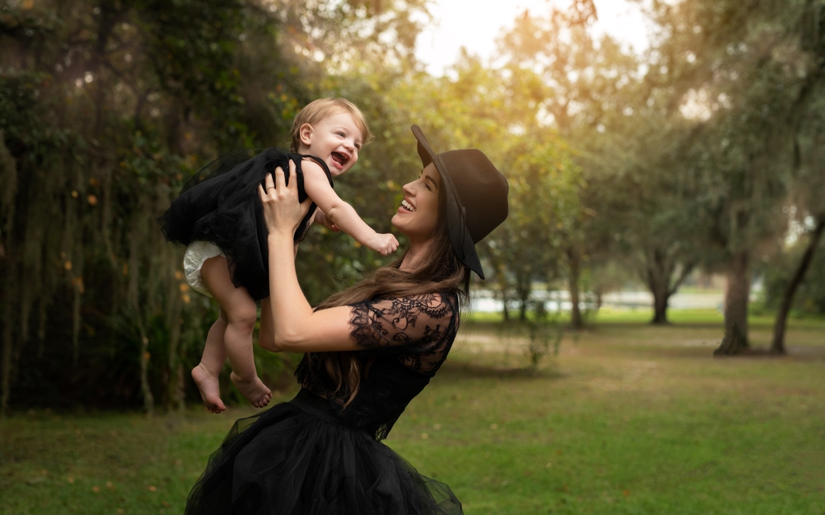 Мама держит улыбающуюся дочь на руках