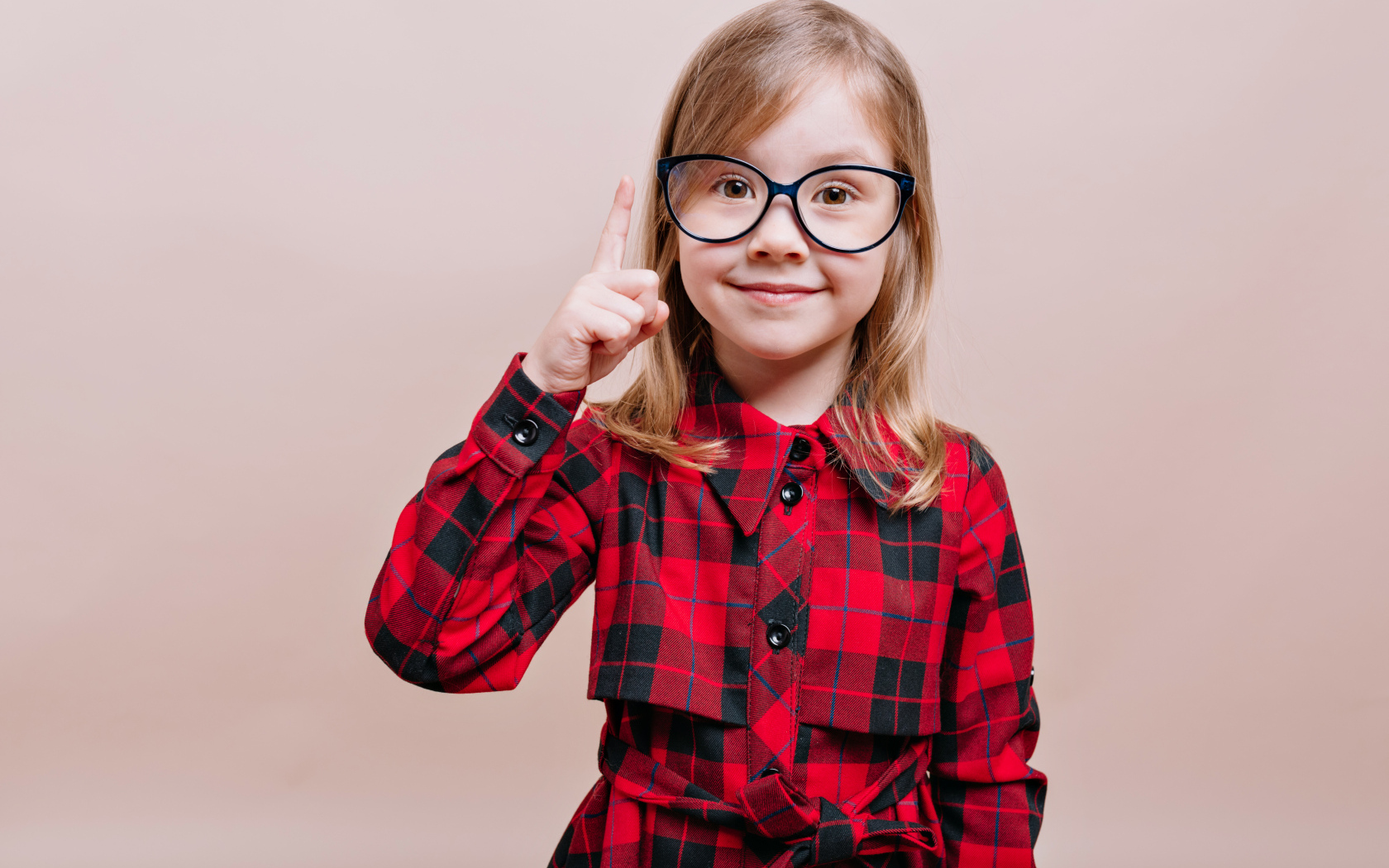 Умная маленькая девочка в платье в очках