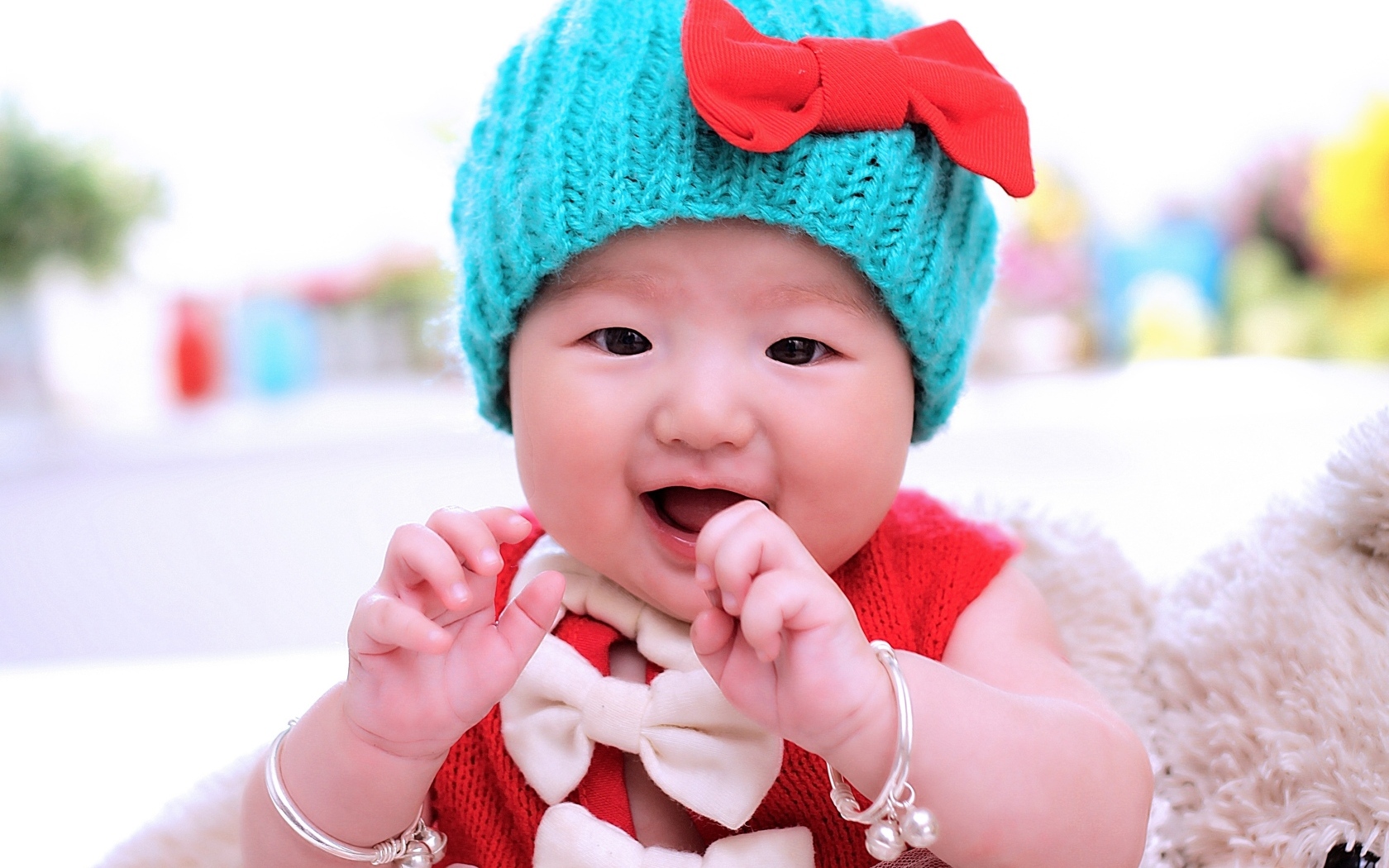 Улыбающаяся девочка в зеленой вязаной шапке