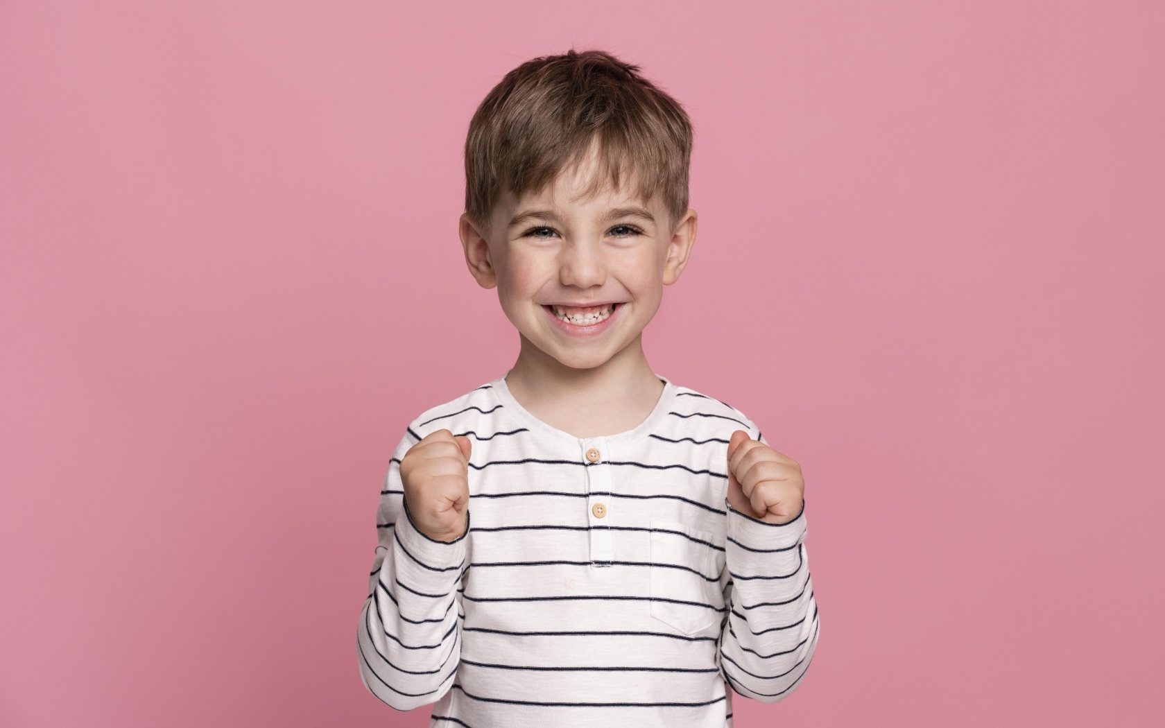 Улыбающийся маленький мальчик на сиреневом фоне