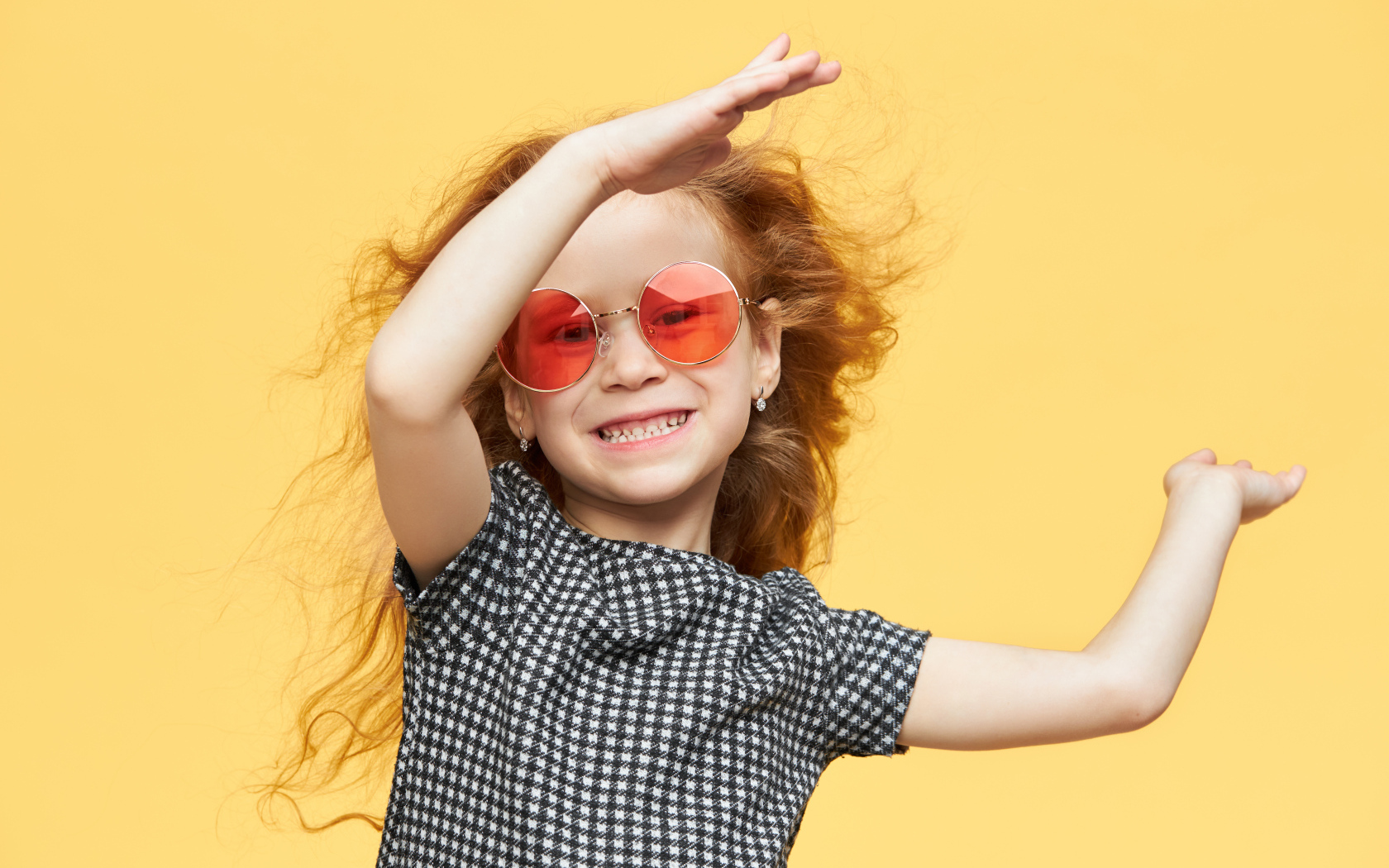 Улыбающаяся рыжеволосая девочка в очках