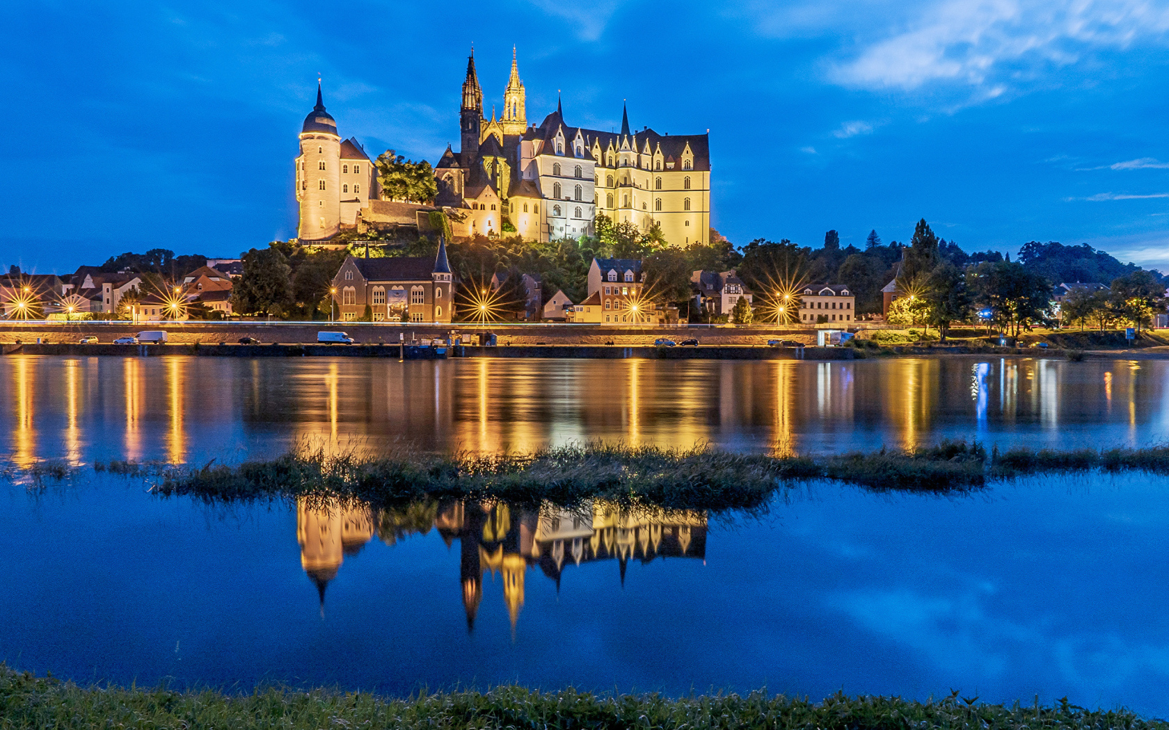 Большой красивый замок отражается в воде ночью, Германия