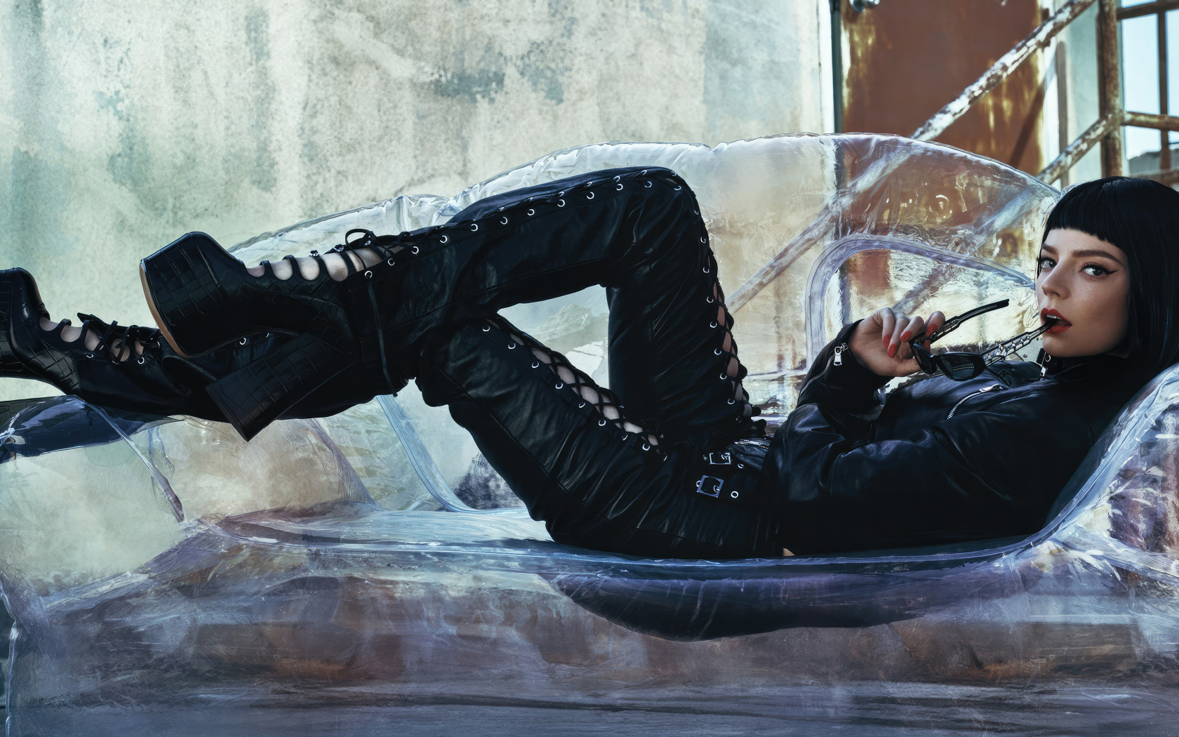 Актриса Аня Тейлор-Джой в черном костюме лежит на диване