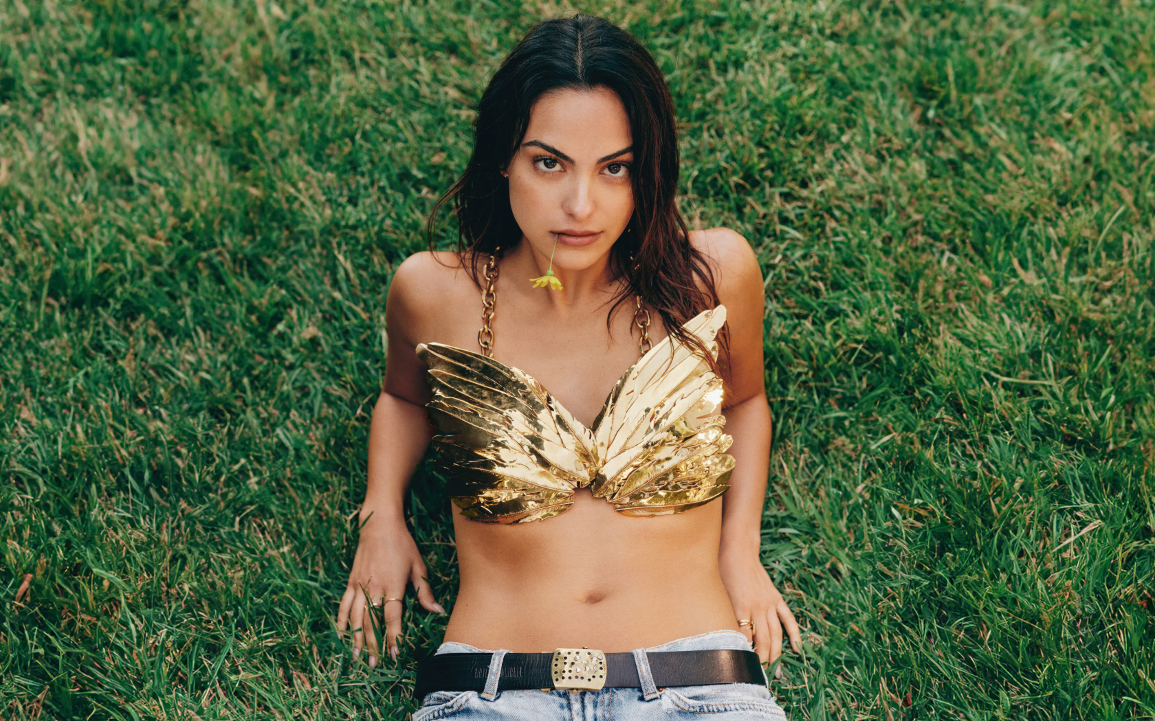 Актриса Камила Мендес лежит на зеленой траве