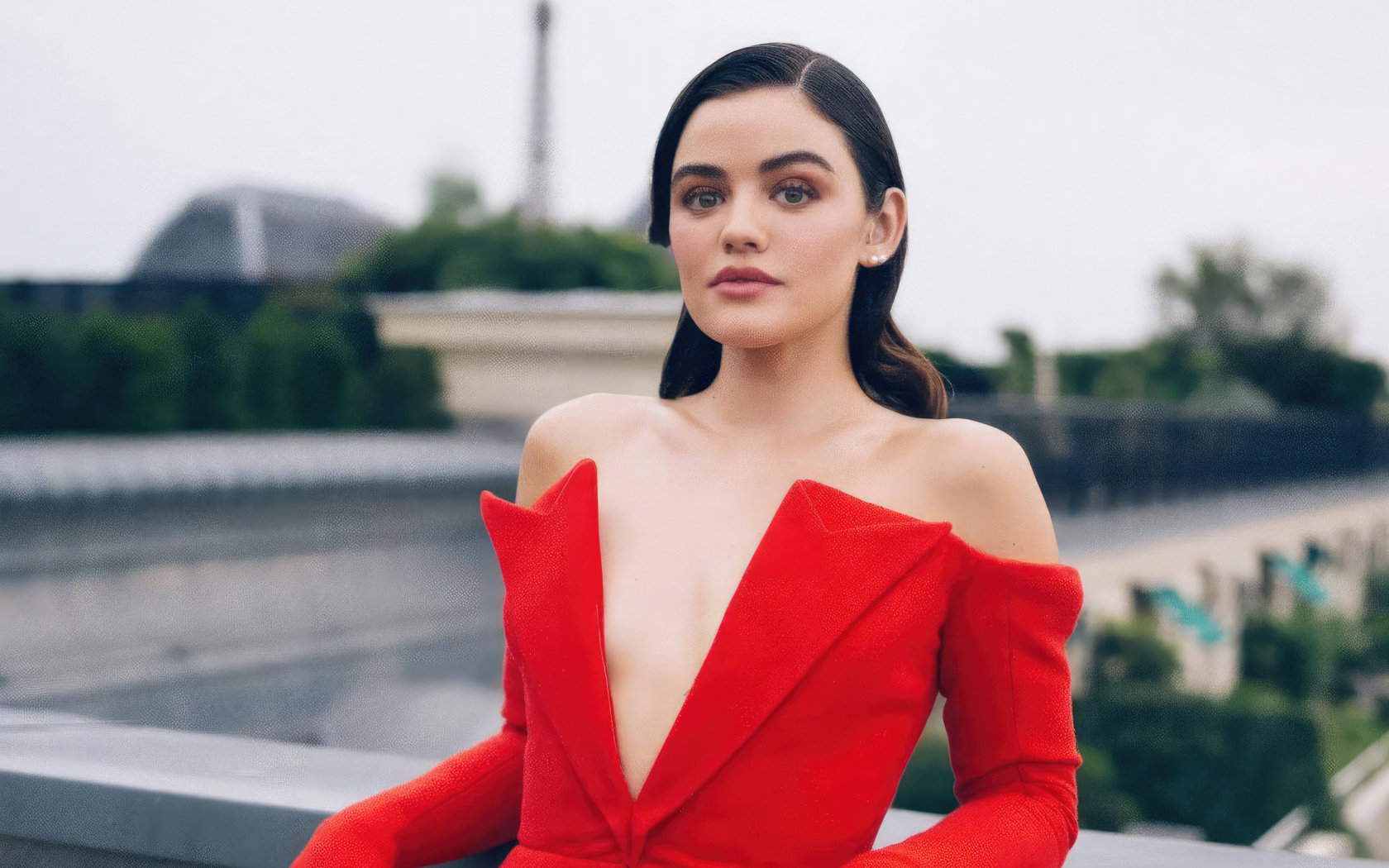 Актриса Люси Хейл в красном наряде стоит на мосту