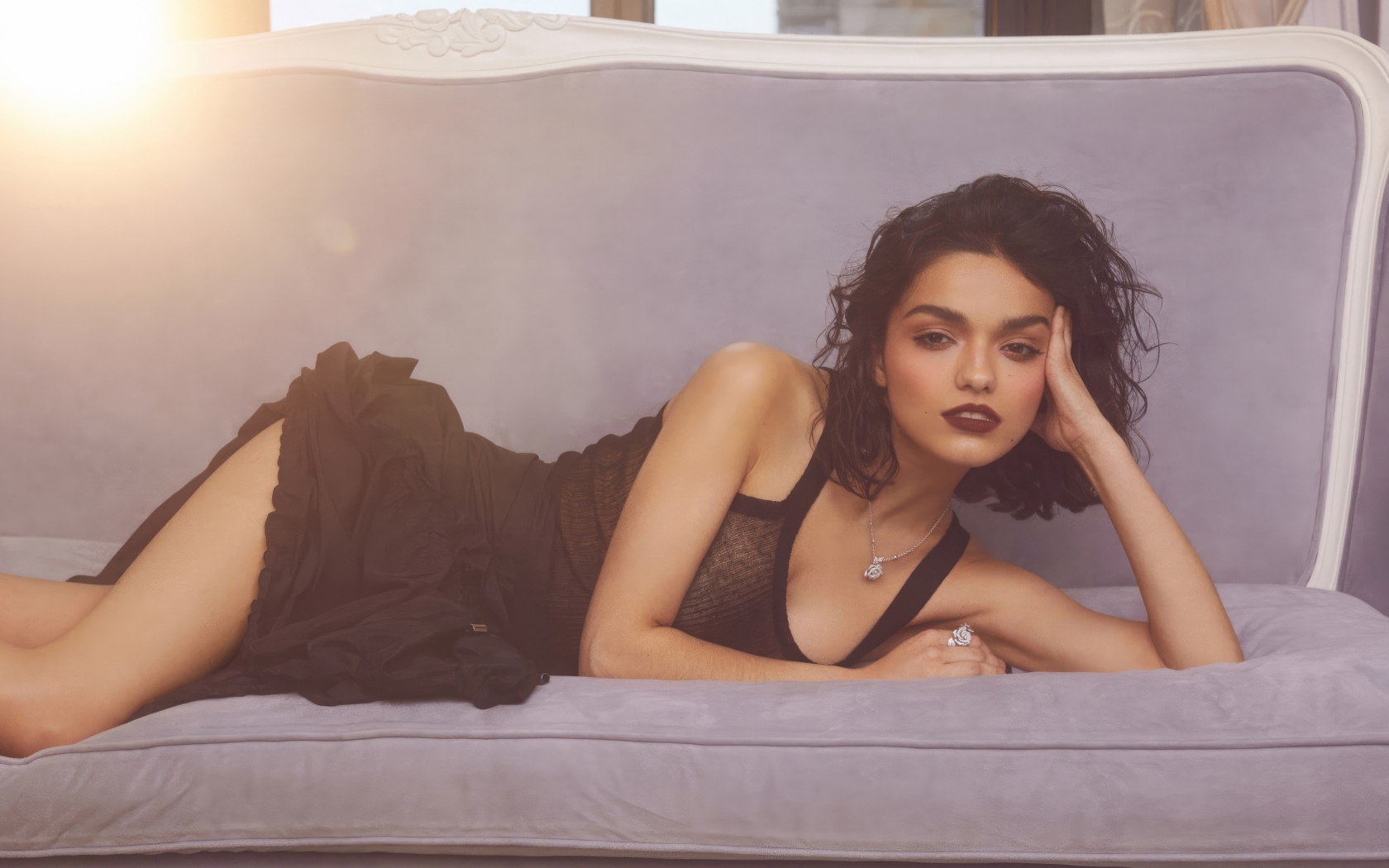 Актриса Рэйчел Зеглер в черном платье лежит на диване