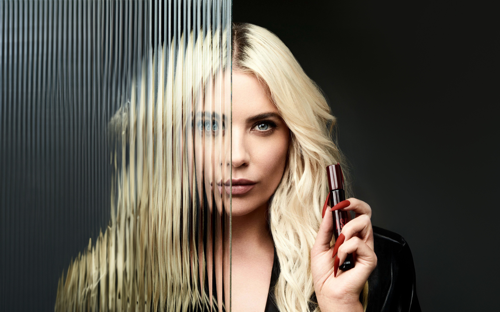 Blonde Ashley Benson stands behind glass