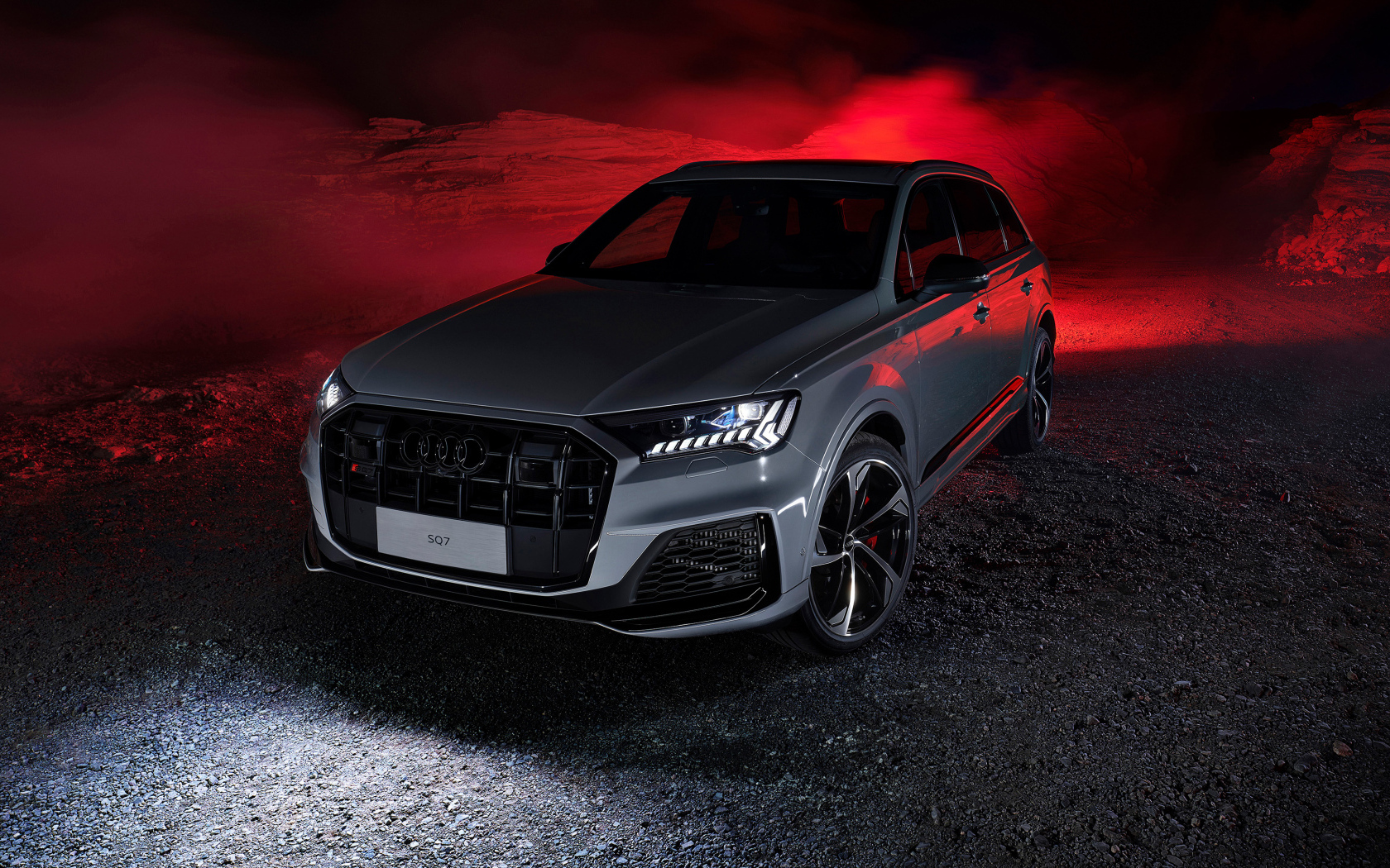Серебристый автомобиль Audi SQ7 в горах ночью
