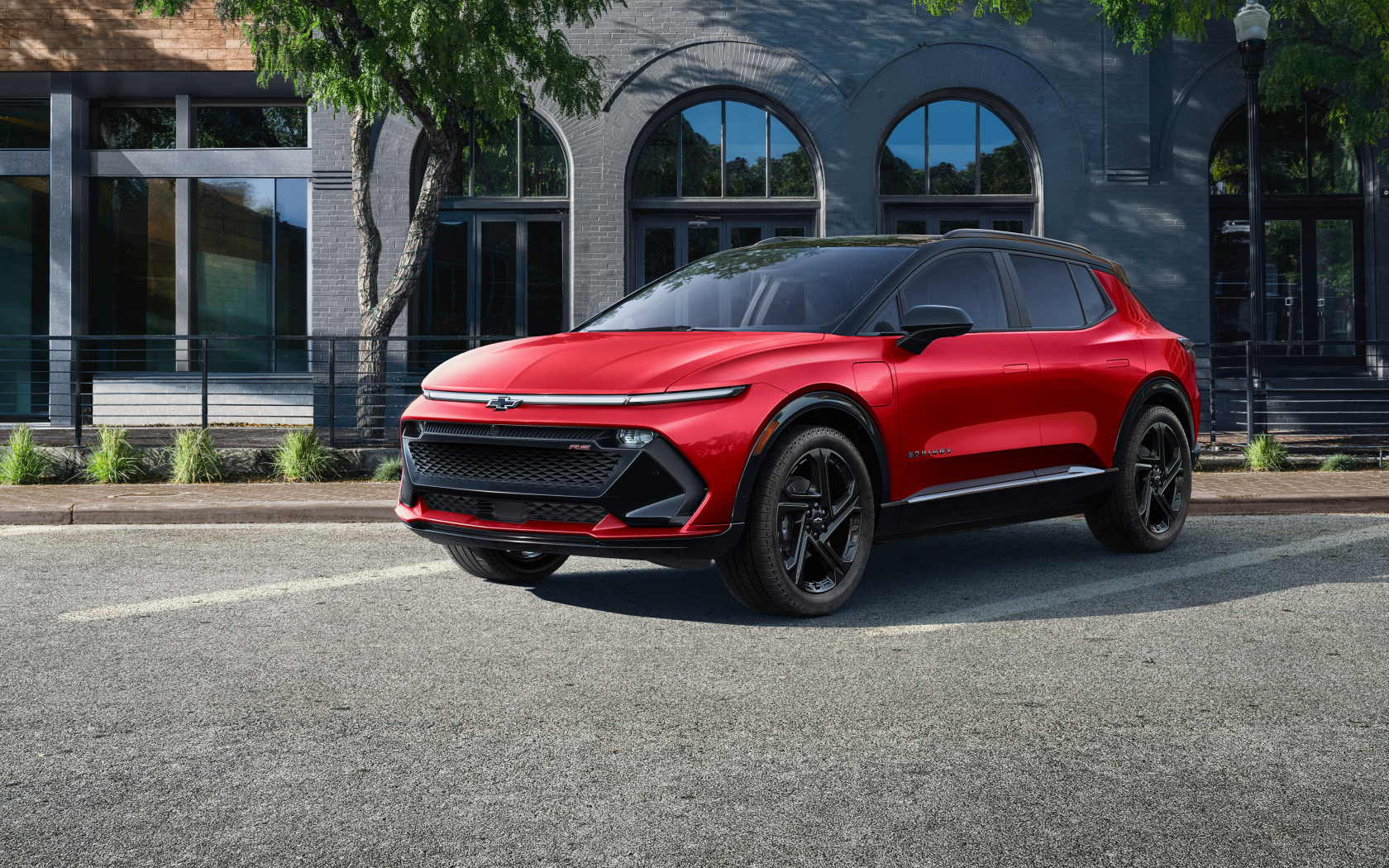 Красный автомобиль Chevrolet Equinox EV 3RS 2024 года у здания