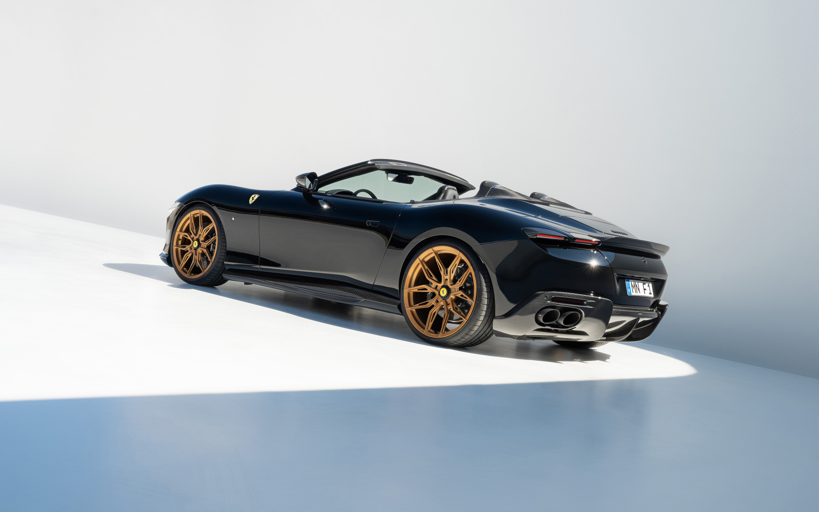 Черный автомобиль Novitec Ferrari Roma Spider 2024 года вид сзади