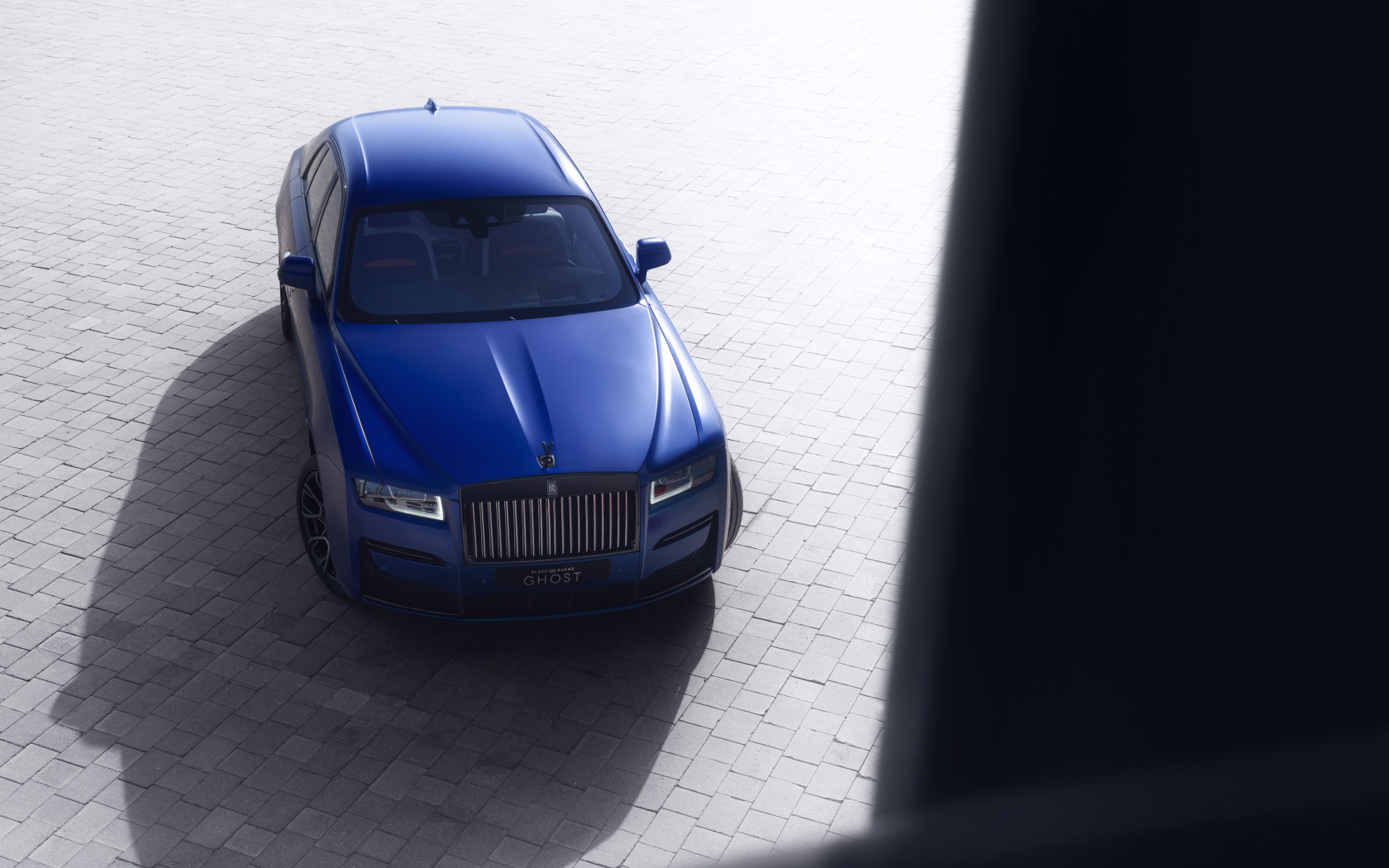 Вид сверху на синий автомобиль Rolls-Royce Black Badge Ghost
