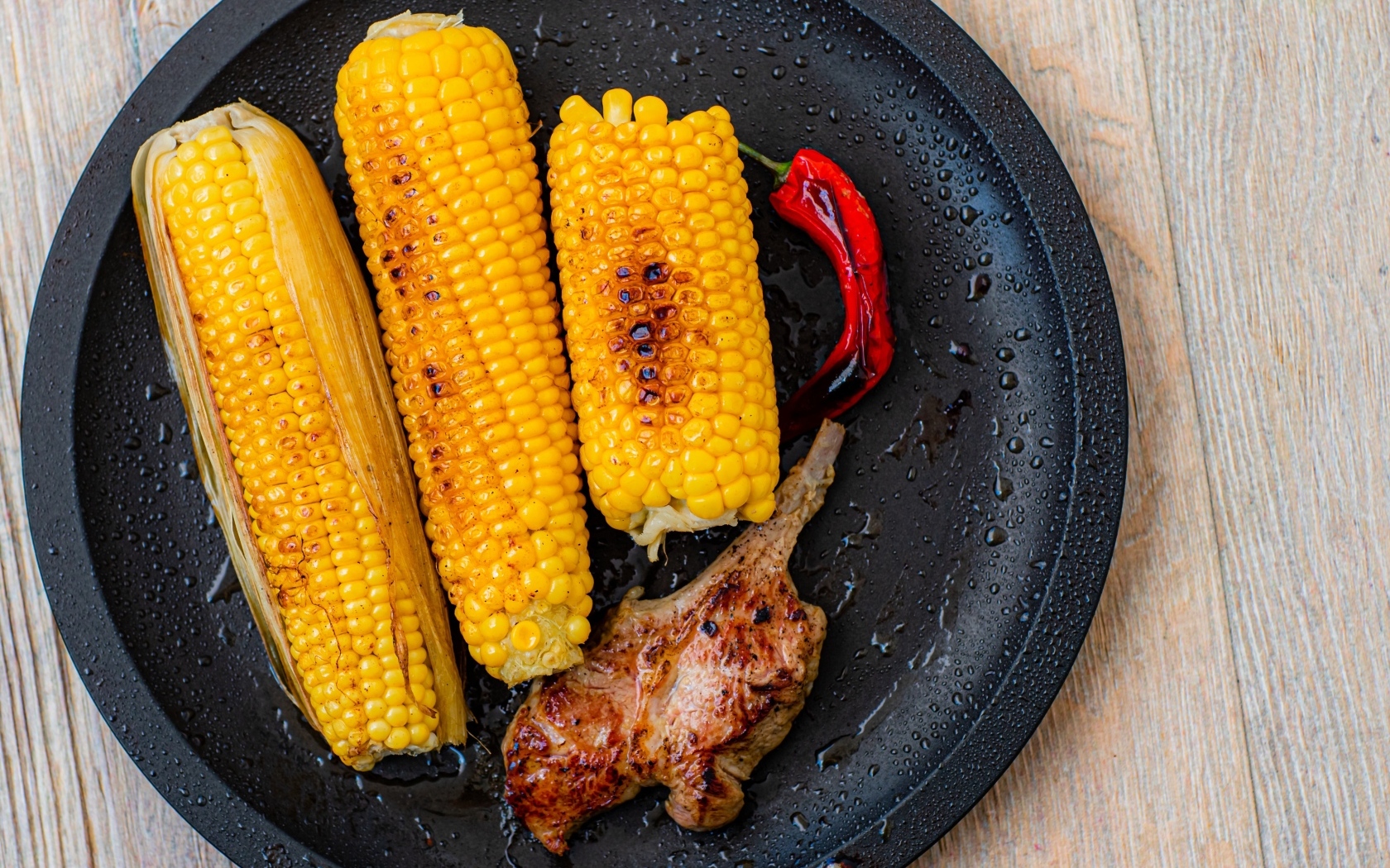 Запеченная кукуруза с ребрышками на тарелке