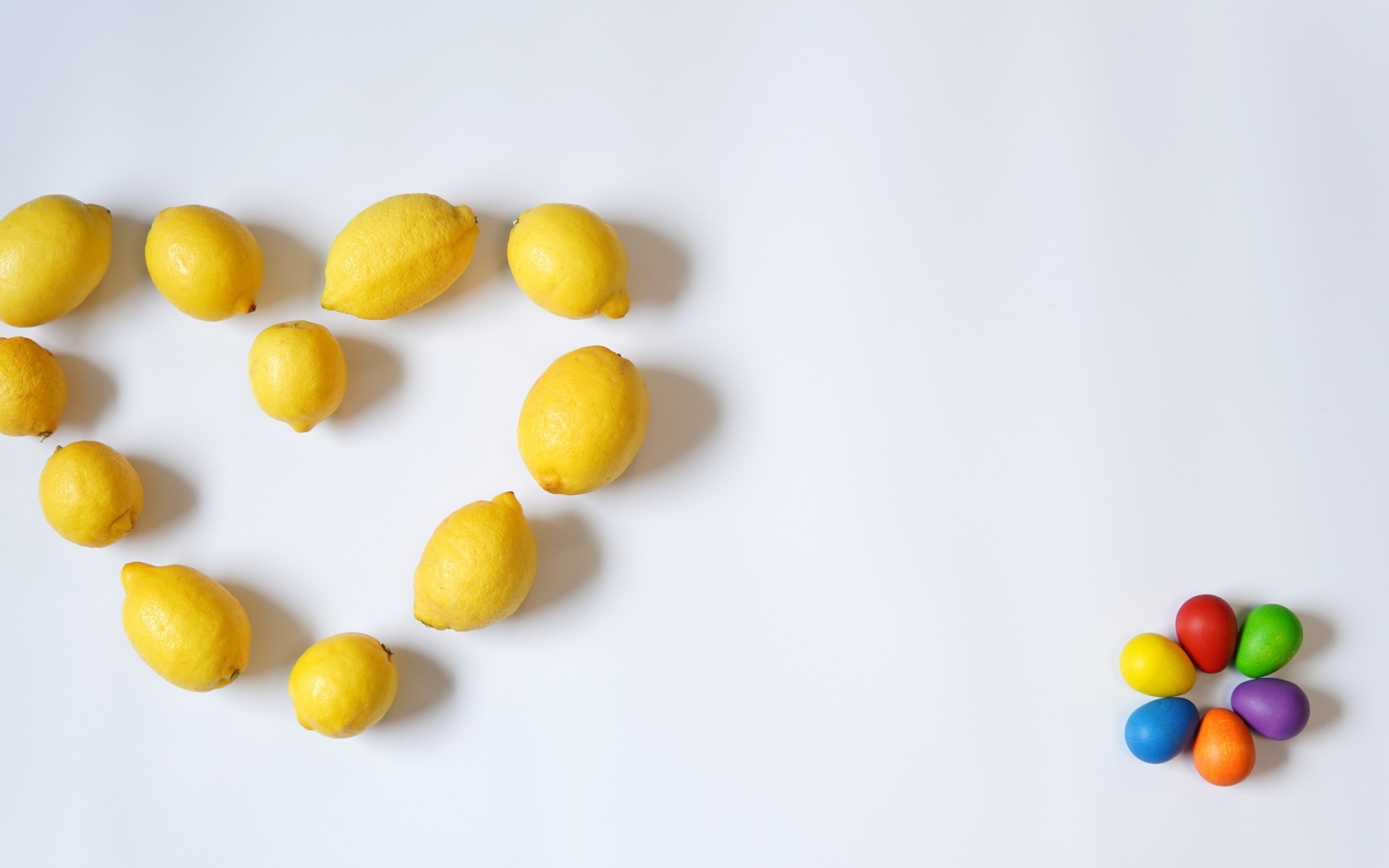 Сердце из желтых лимонов на сером фоне с конфетами