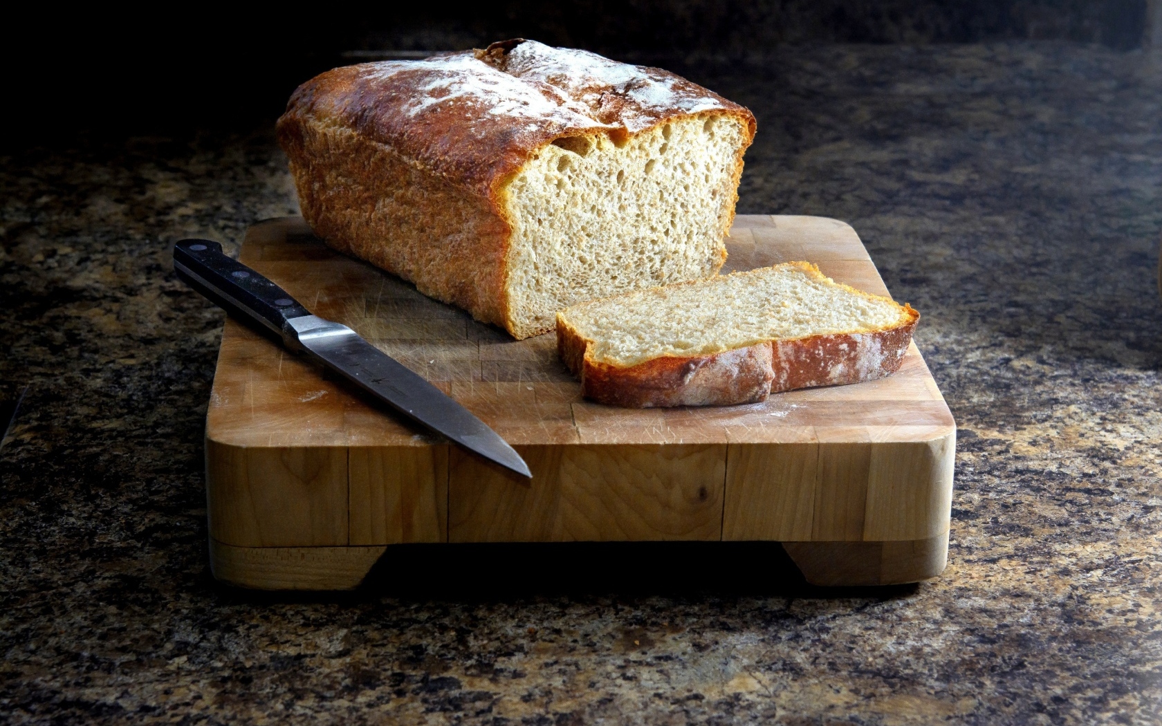 Буханка хлеба с ножом на столе