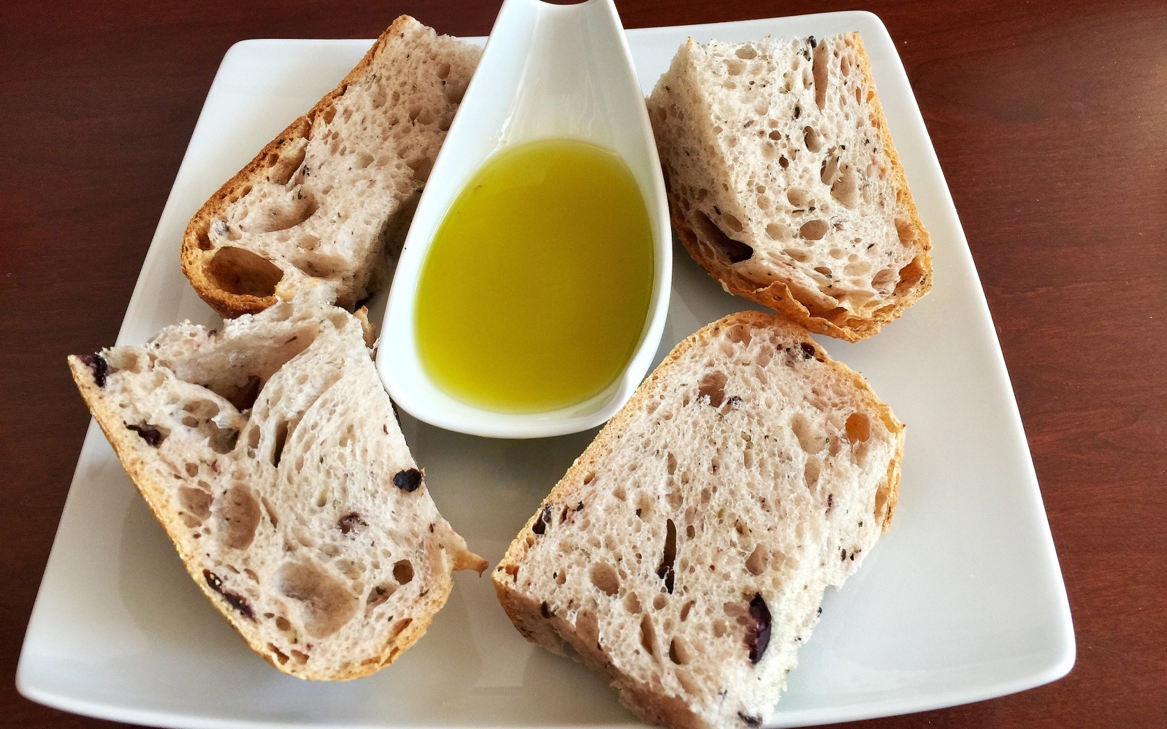 Ломти хлеба на тарелке с оливковым маслом