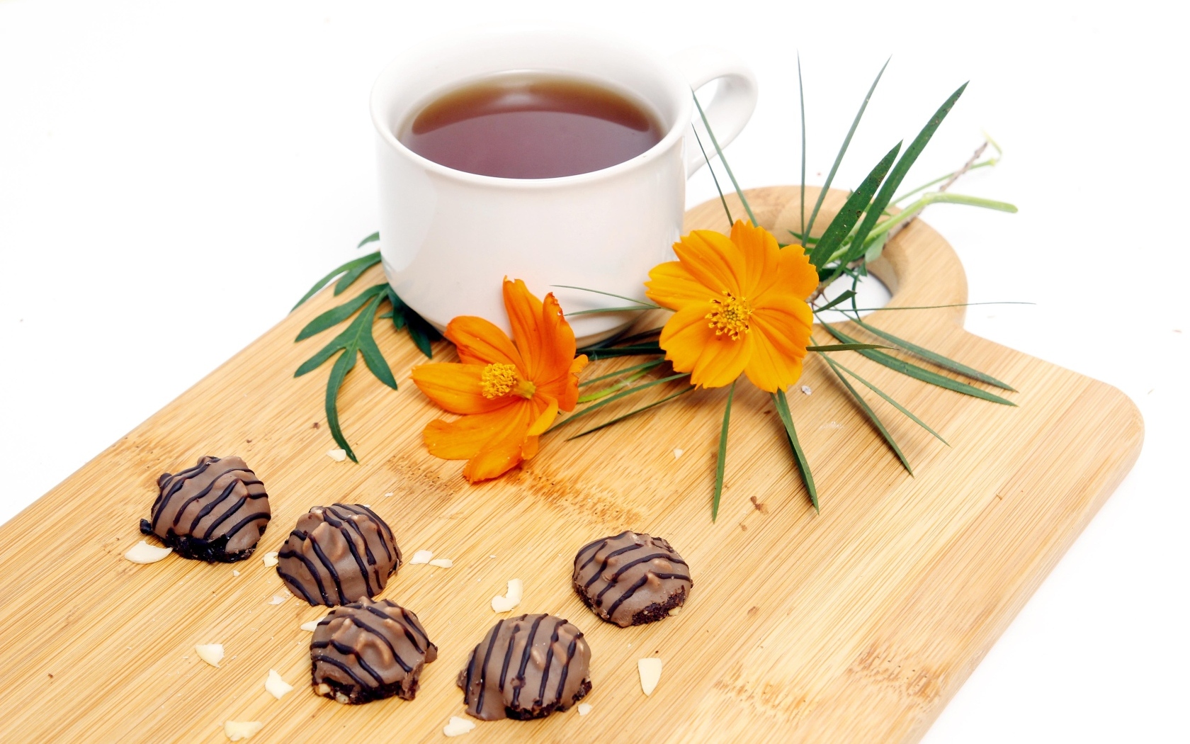 Чашка чая на деревянной доске с конфетами