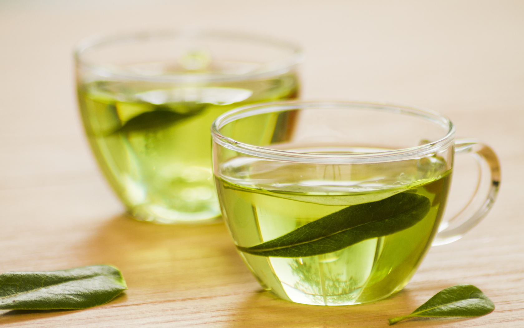 Две чашки зеленого чая с листьями