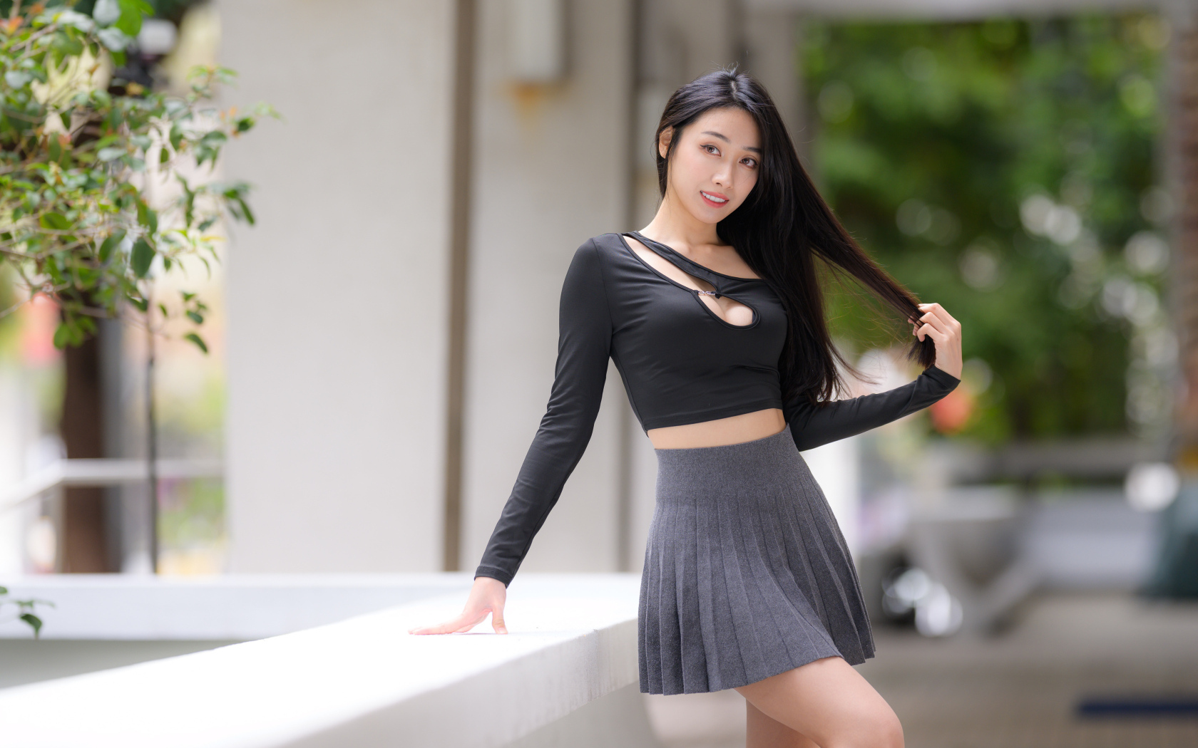 Молодая азиатка в короткой серой юбке