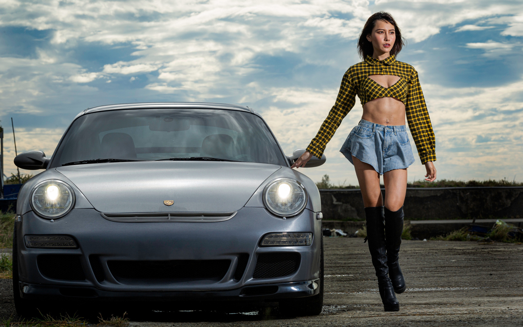 Молодая азиатка стоит у автомобиля