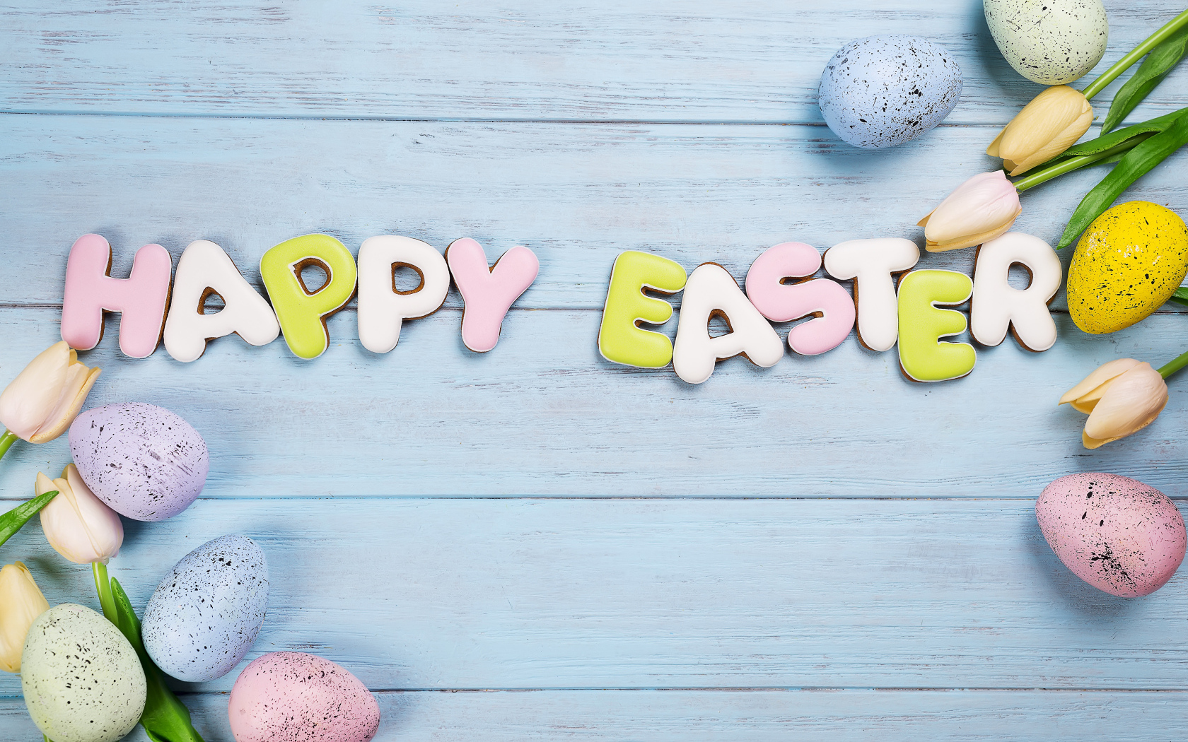 Печенье с надписью счастливой Пасхи с яйцами и цветами