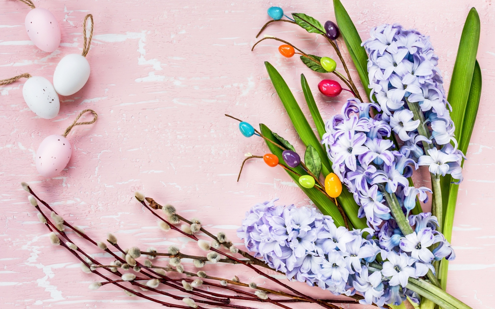 Цветы гиацинта с ветками вербы и яйцами на розовом фоне