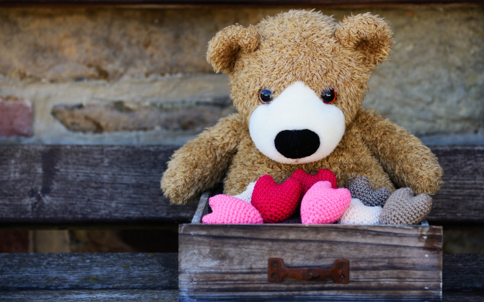 Игрушечный медвежонок с сердечками в деревянном ящике