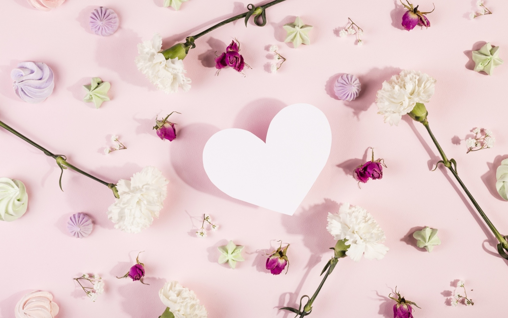 Белое бумажное сердце на розовом фоне с цветами