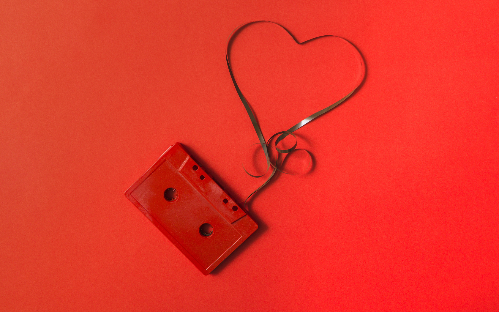 Кассета с сердцем из ленты на красном фоне