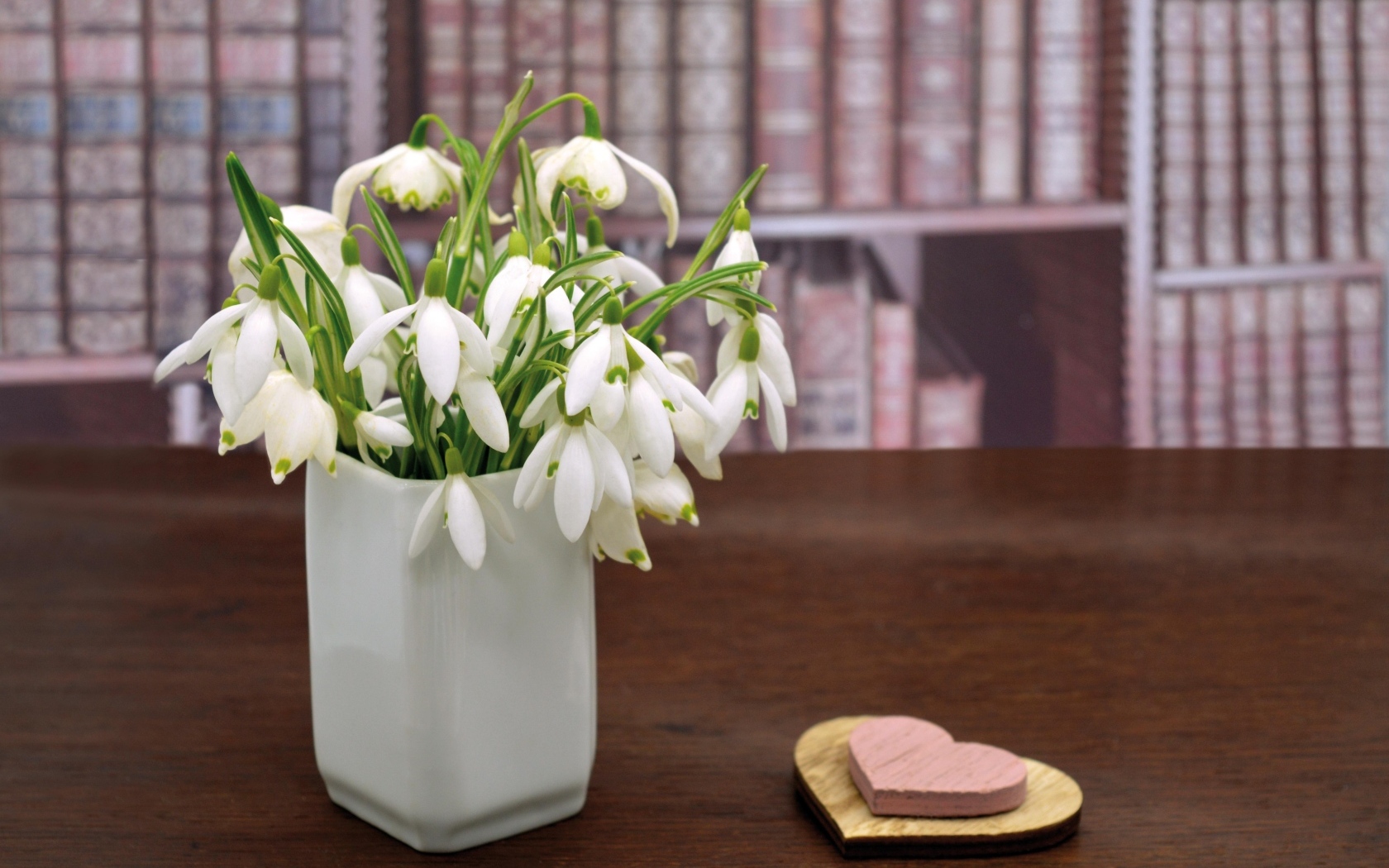 Букет белых подснежников в вазе на столе с сердечками