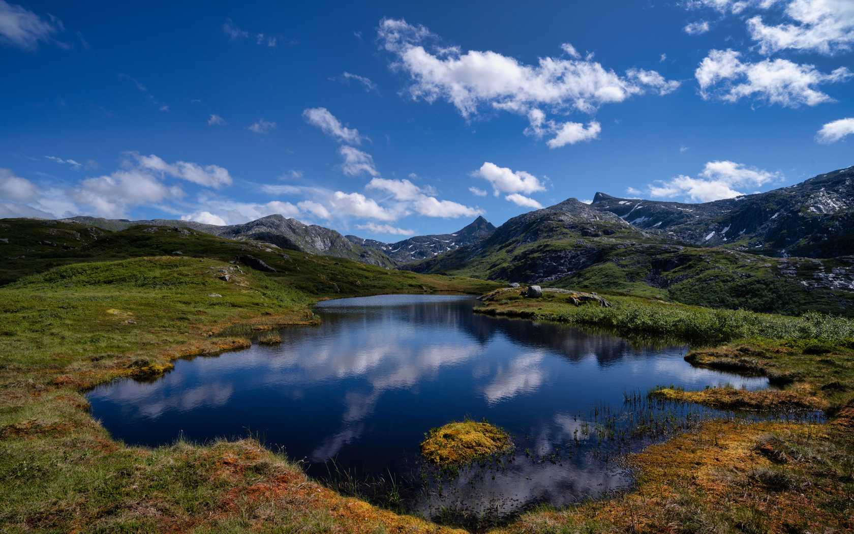 Маленькое озеро в горах под голубым небом
